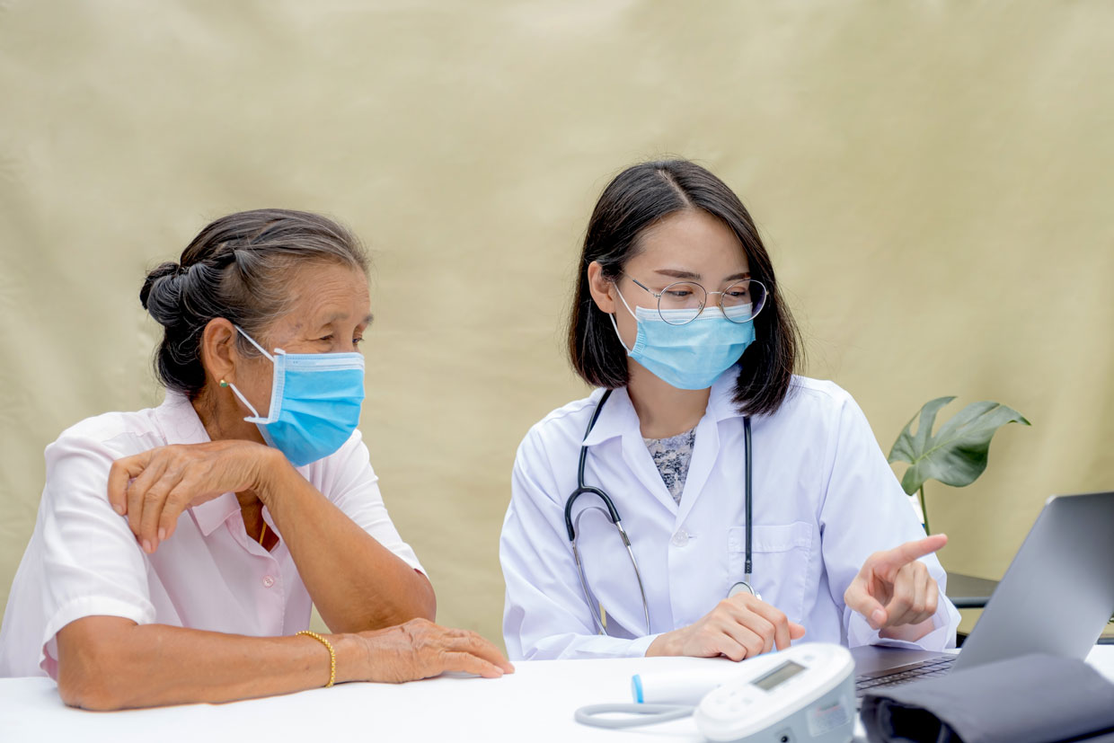 young female doctor talking to an old female patient