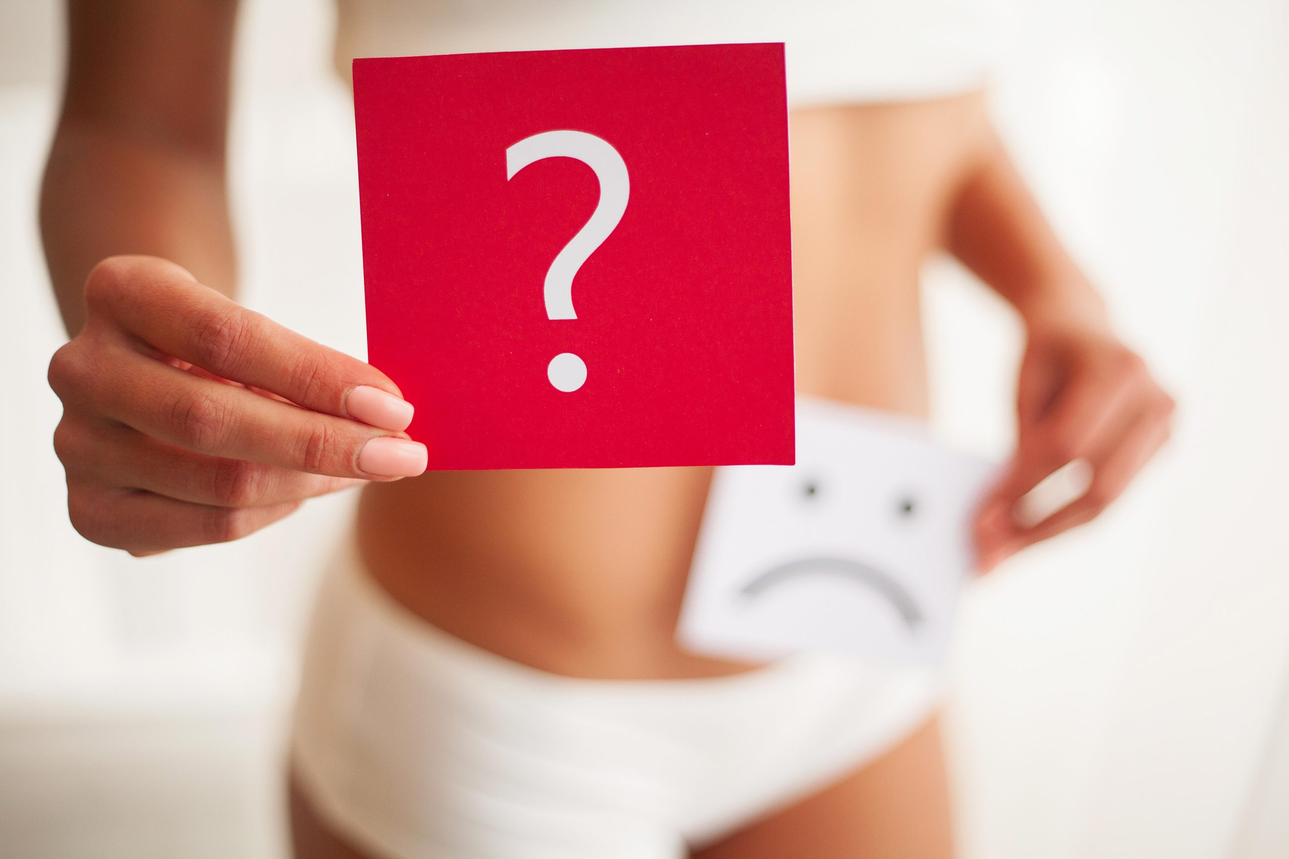 female holding a sign with a question mark