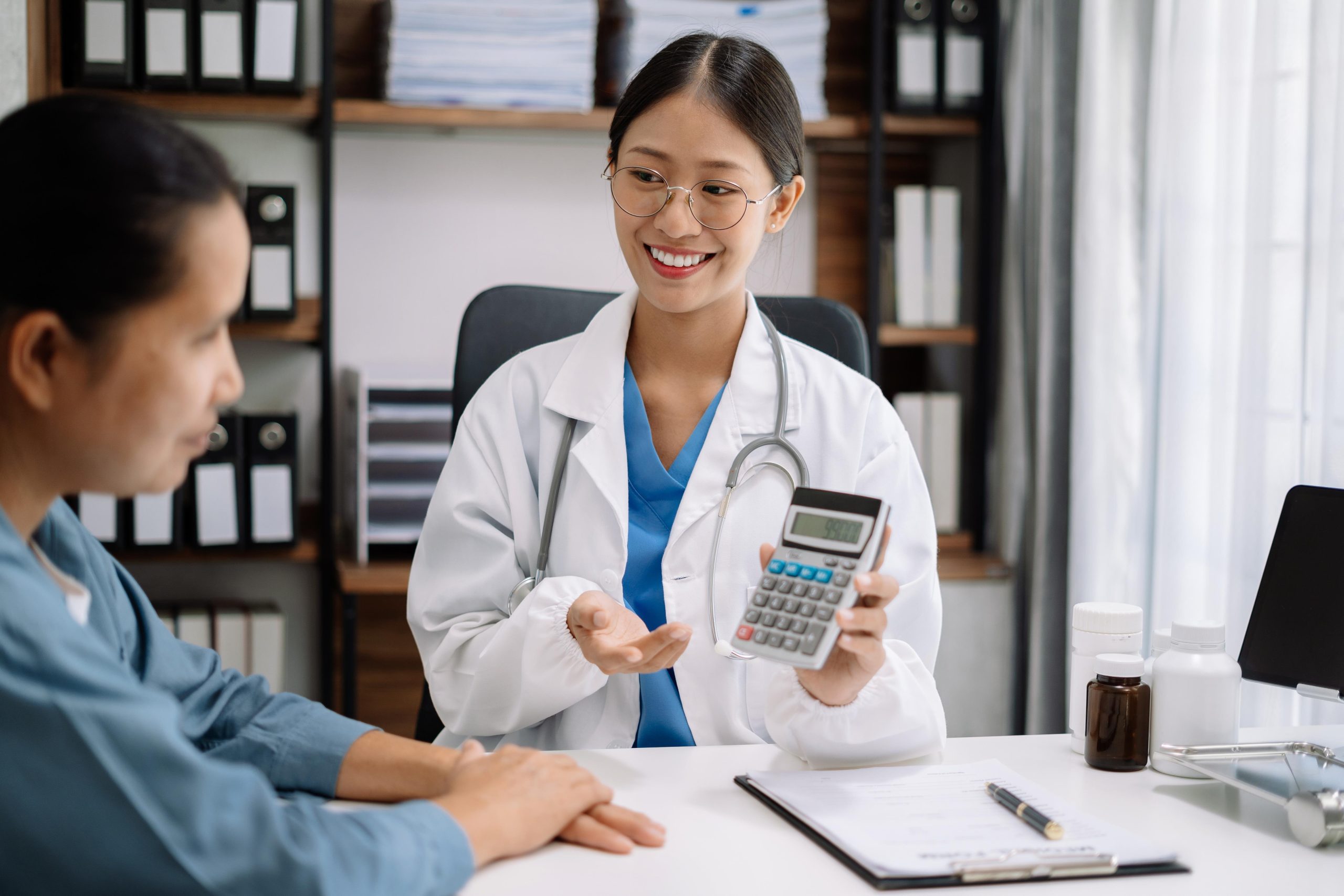 healthcare worker with a calculator speaking with a patient