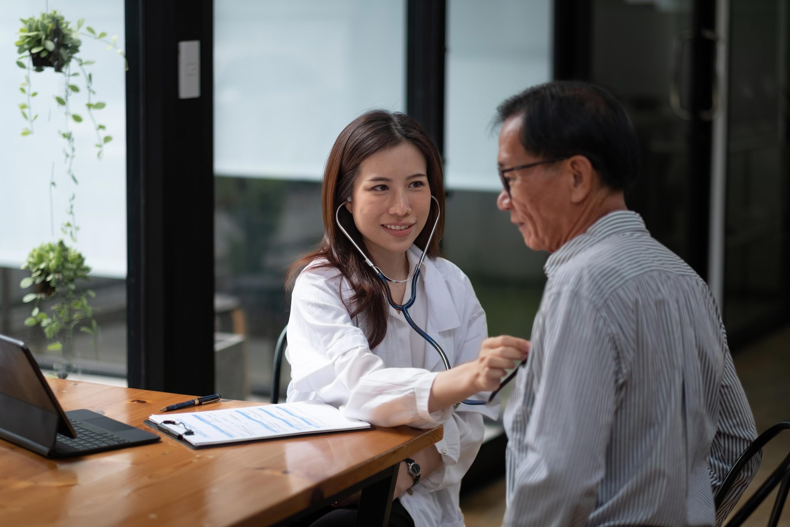young female doctor examining an elderly male patient