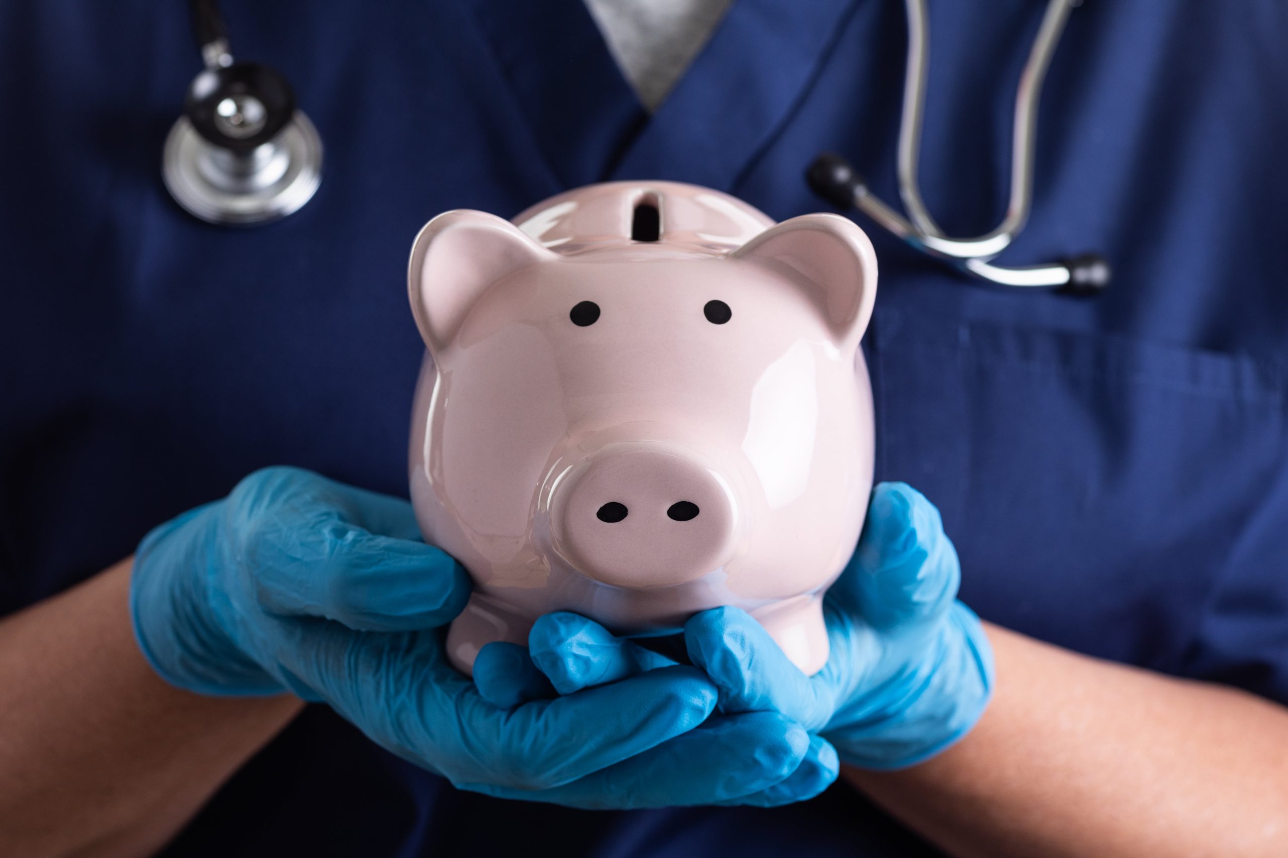 healthcare workder holding a piggy bank