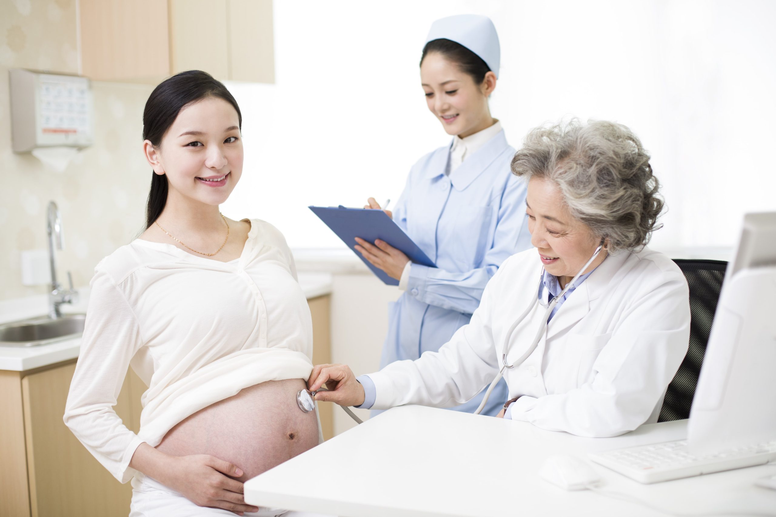 pregnant woman being examined by a doctor and a nurse
