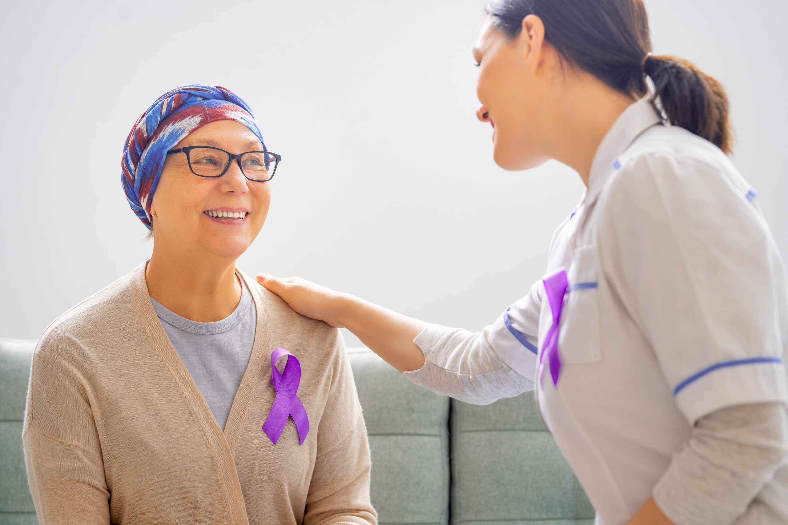 cancer patient smiling and speaking with a healthcare worker