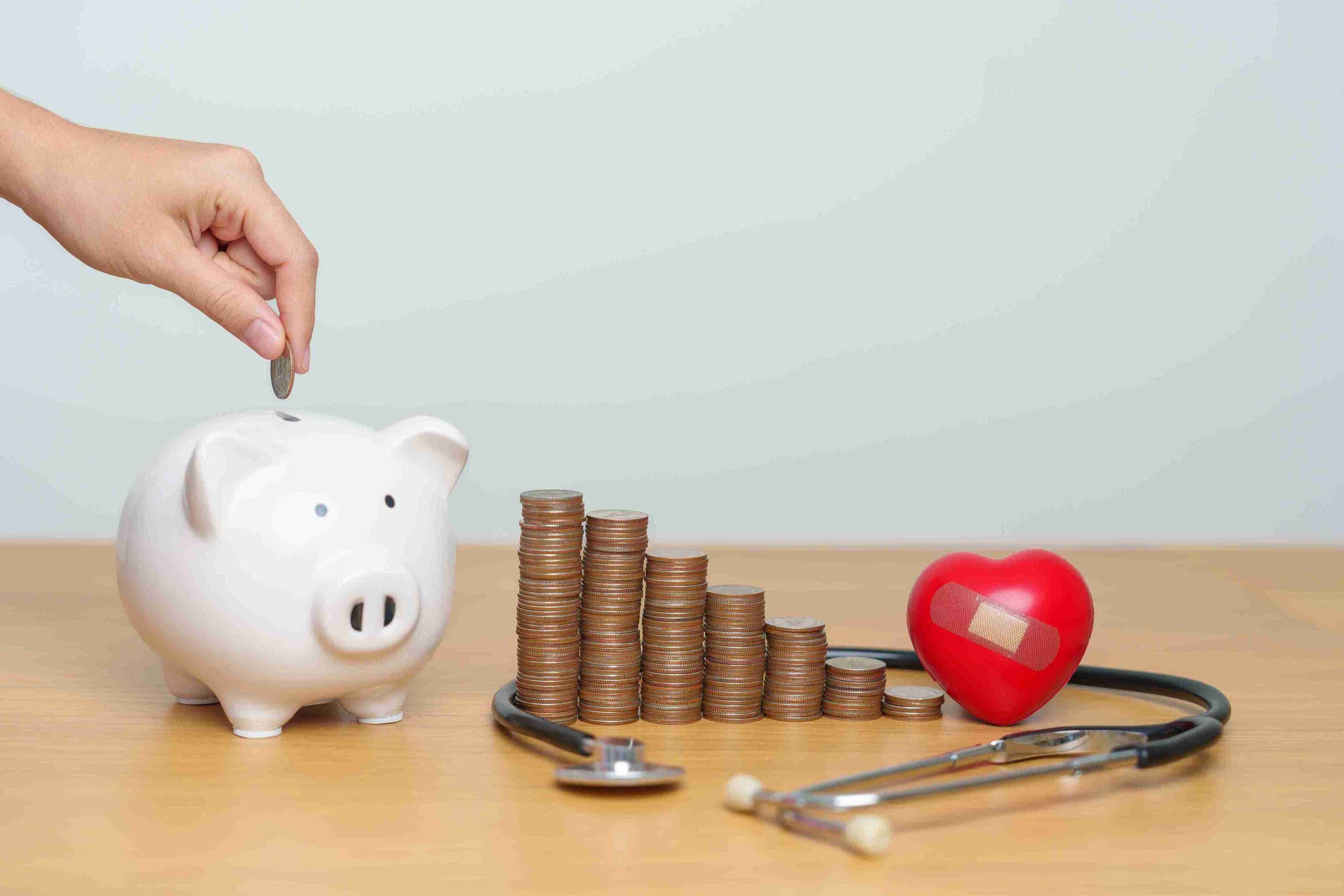 piggy bank, coins, and stethoscope on the table