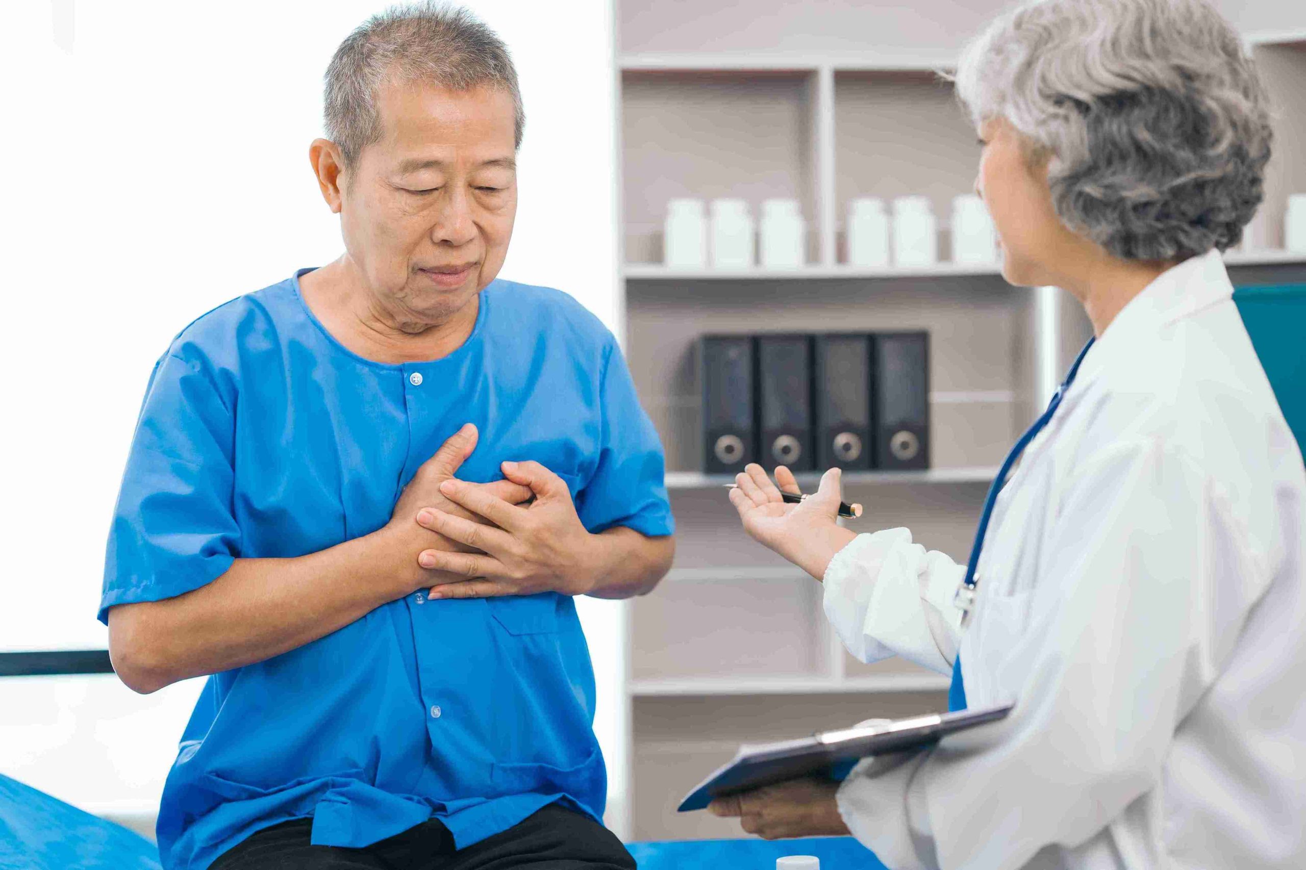 senior male patient with his hand on his heart