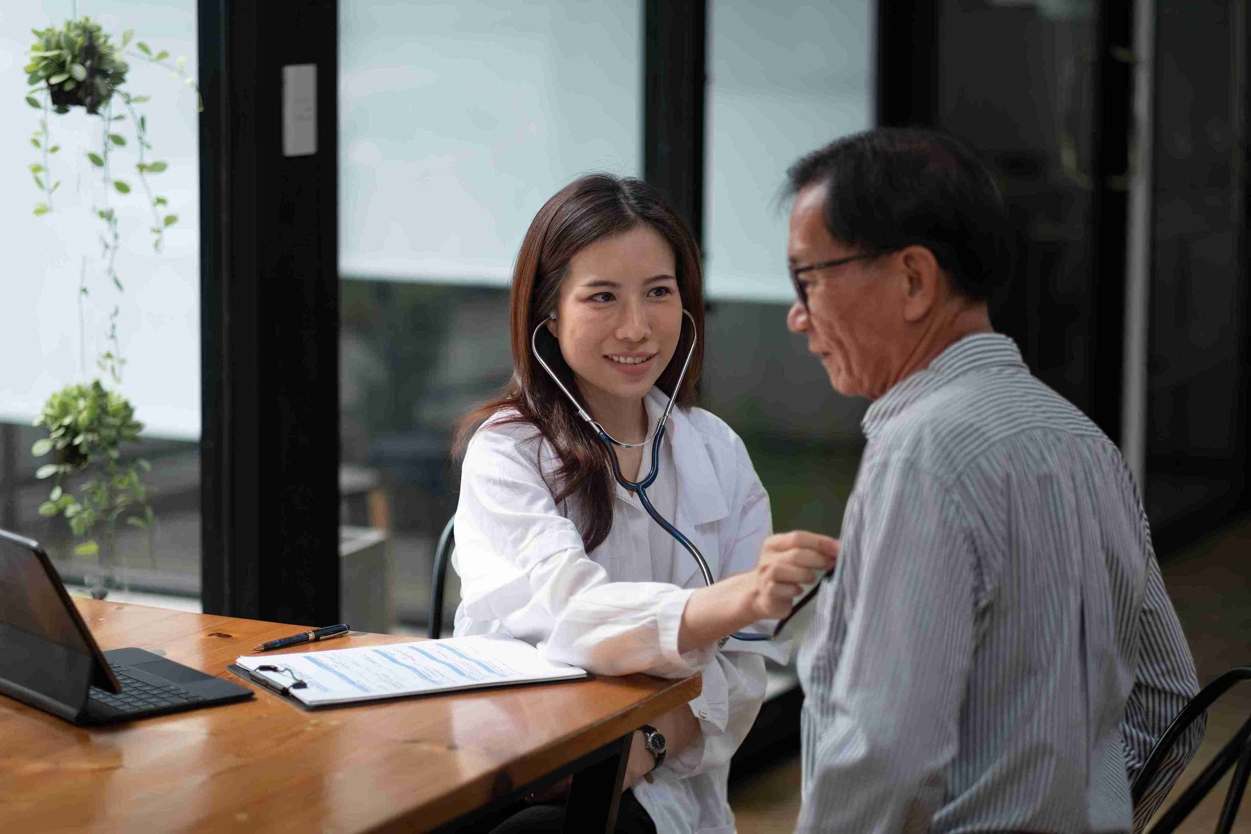 female doctor checking the vital signs of elderly patient