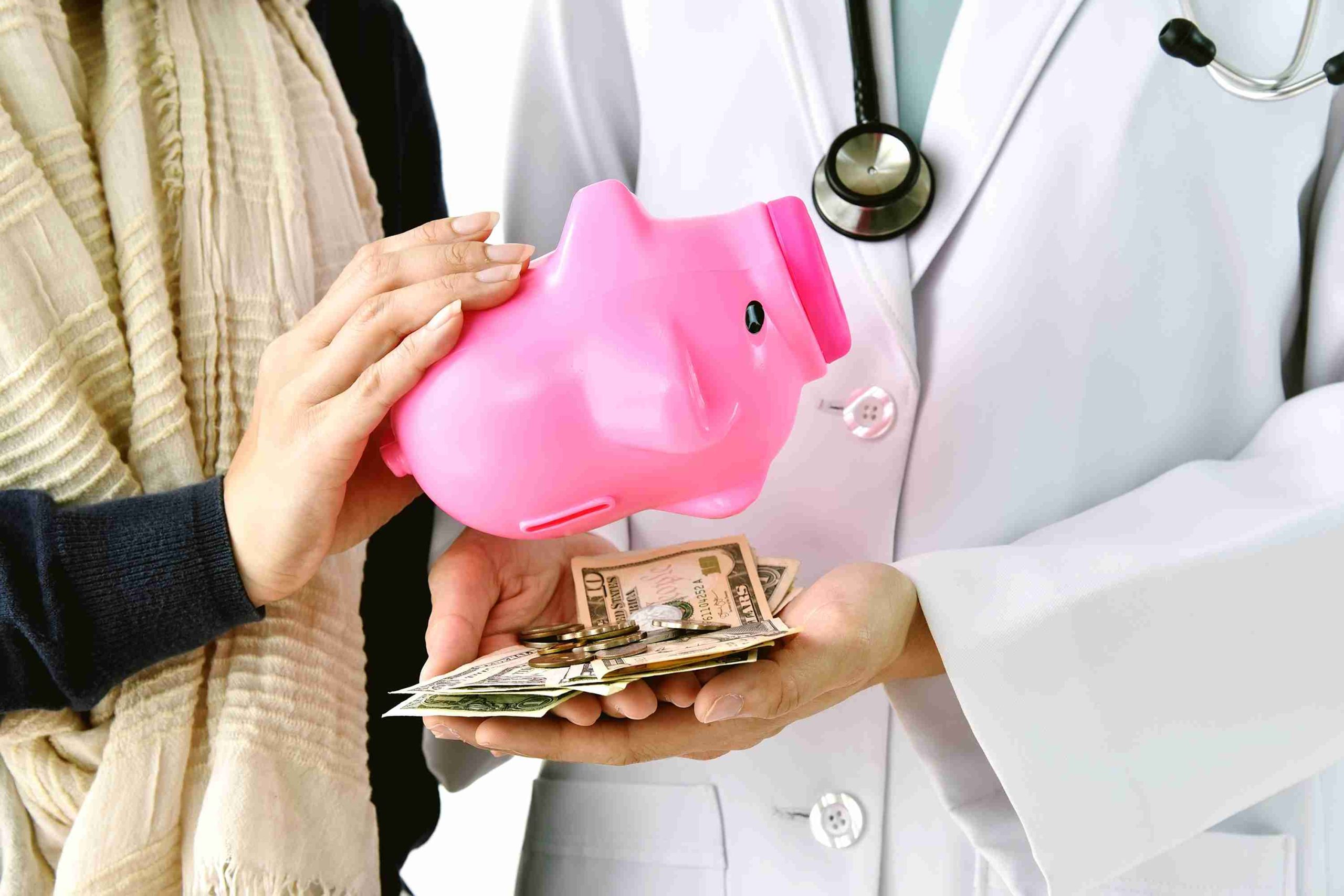 patient pouring contents of piggy bank in the hands of a doctor