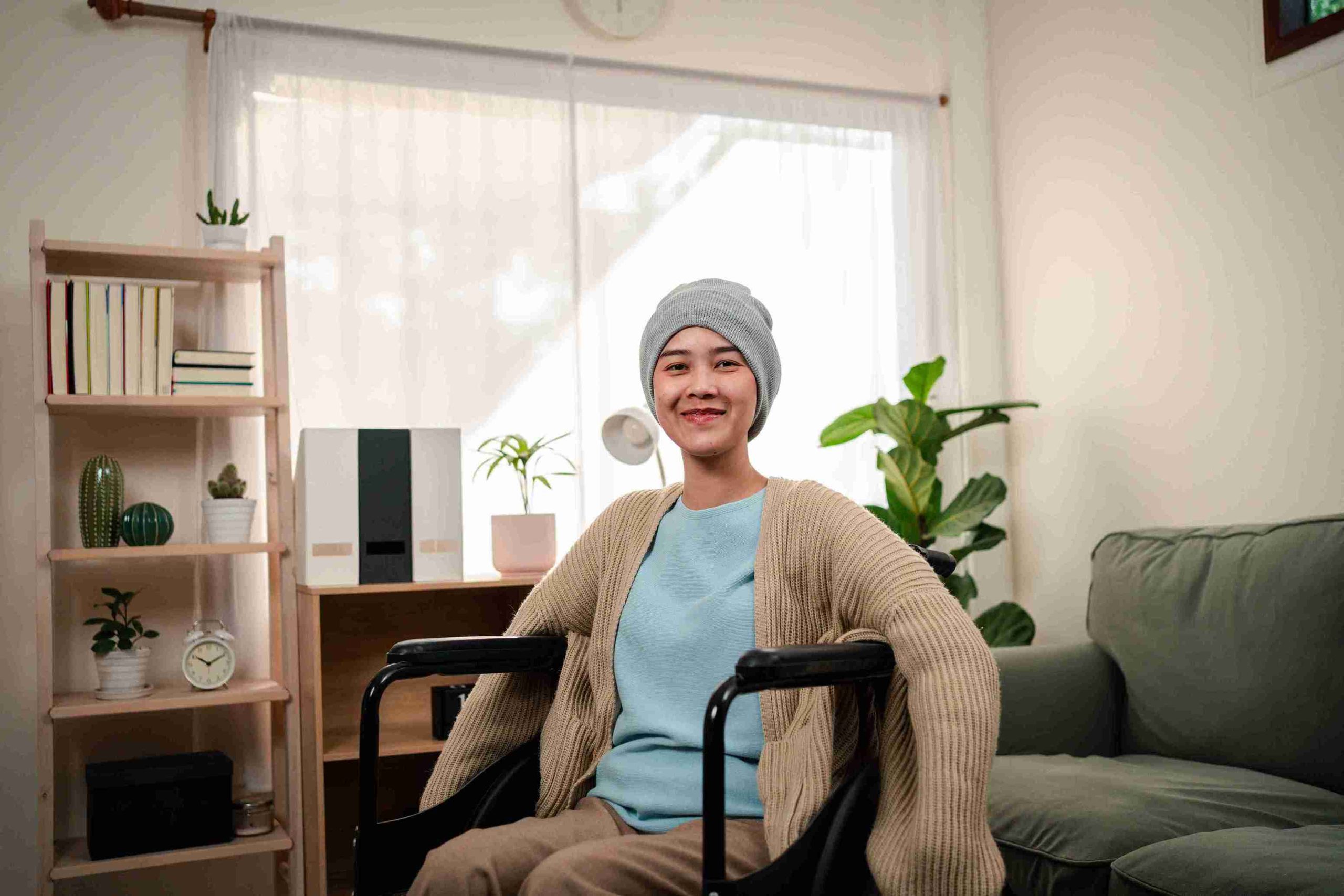 female cancer patient sitting in a wheelchair and smiling at the camera