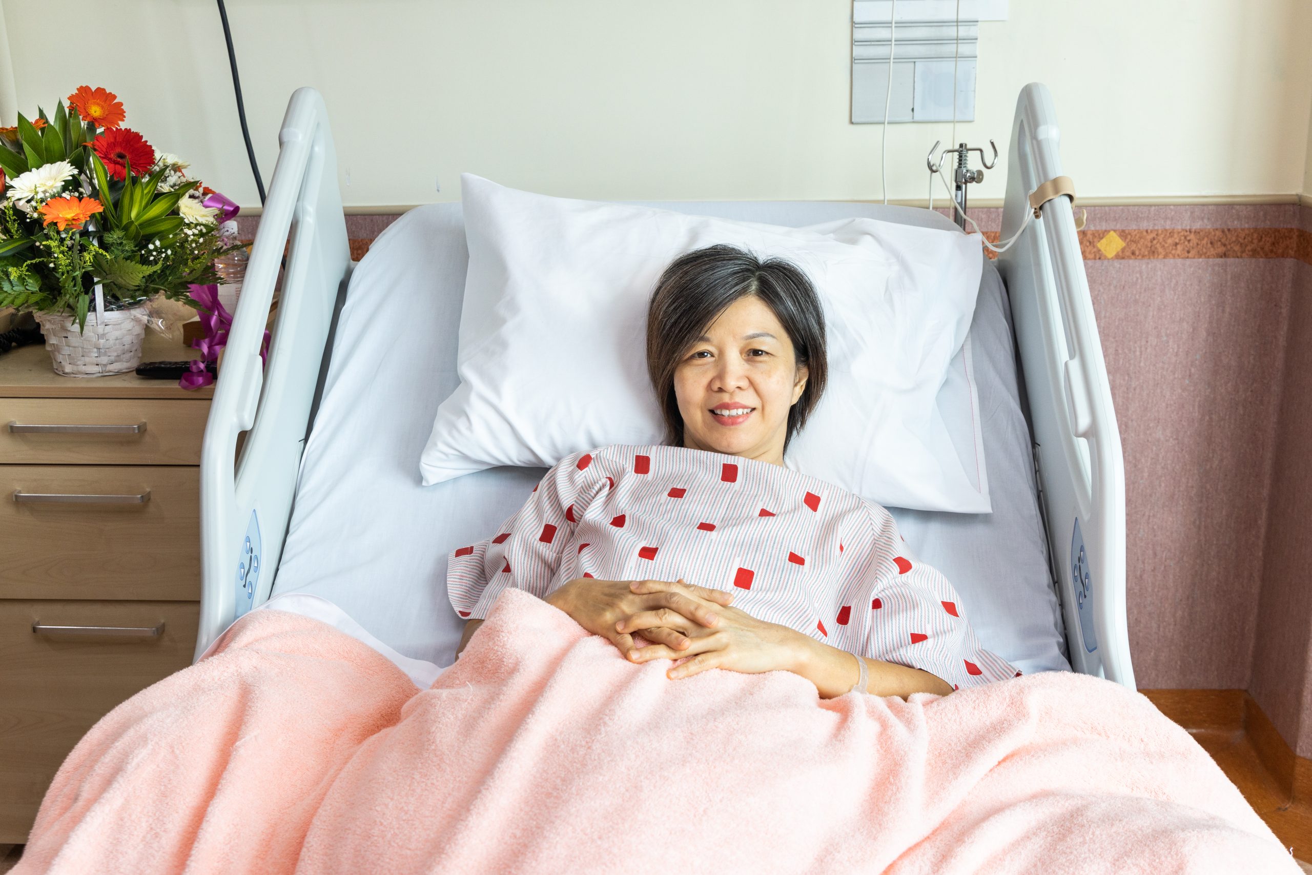 asian woman lying in bed and smiling