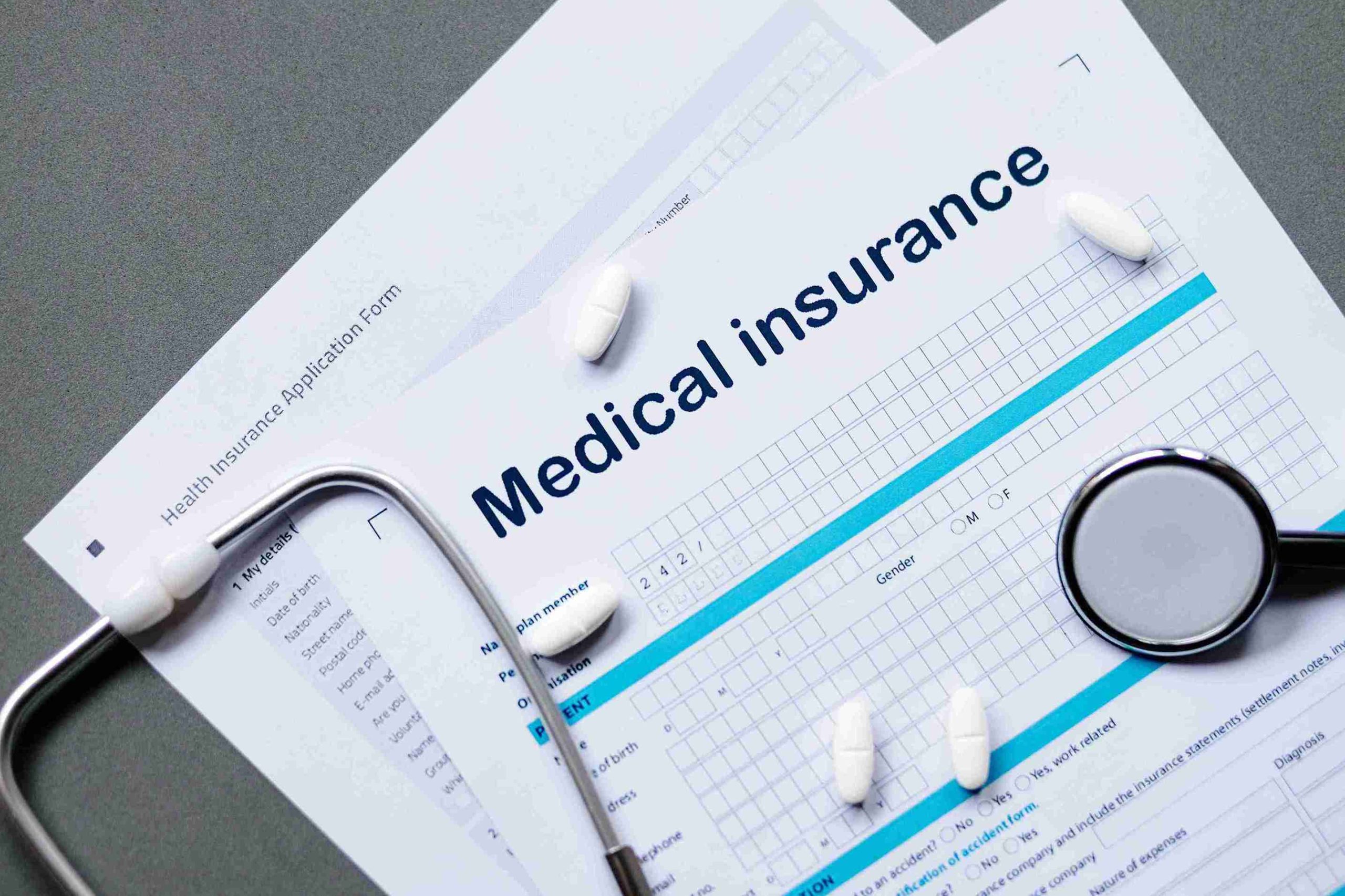 image of insurance papers, stetoscope, and medicines