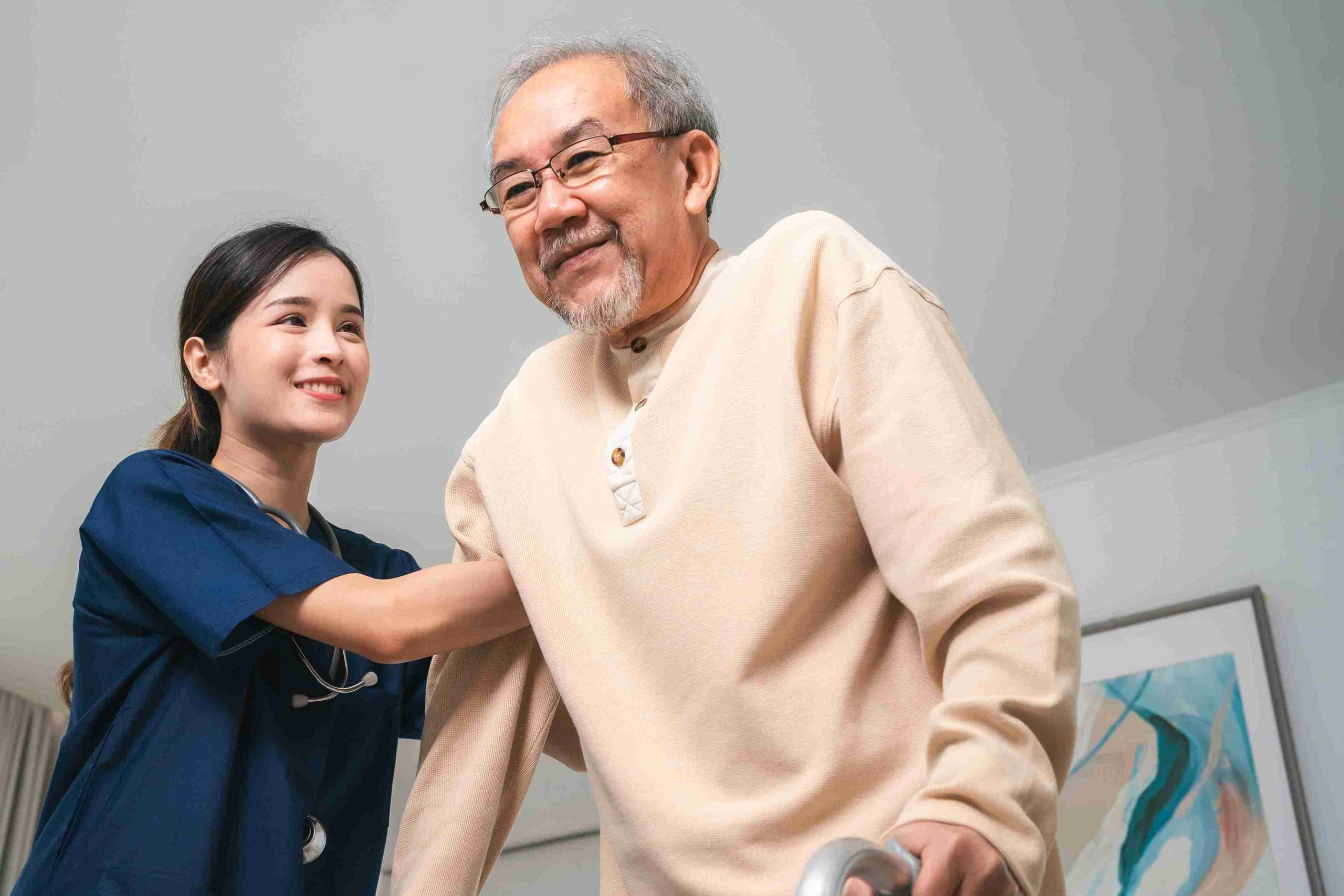 elderly man supported by a healthcare worker