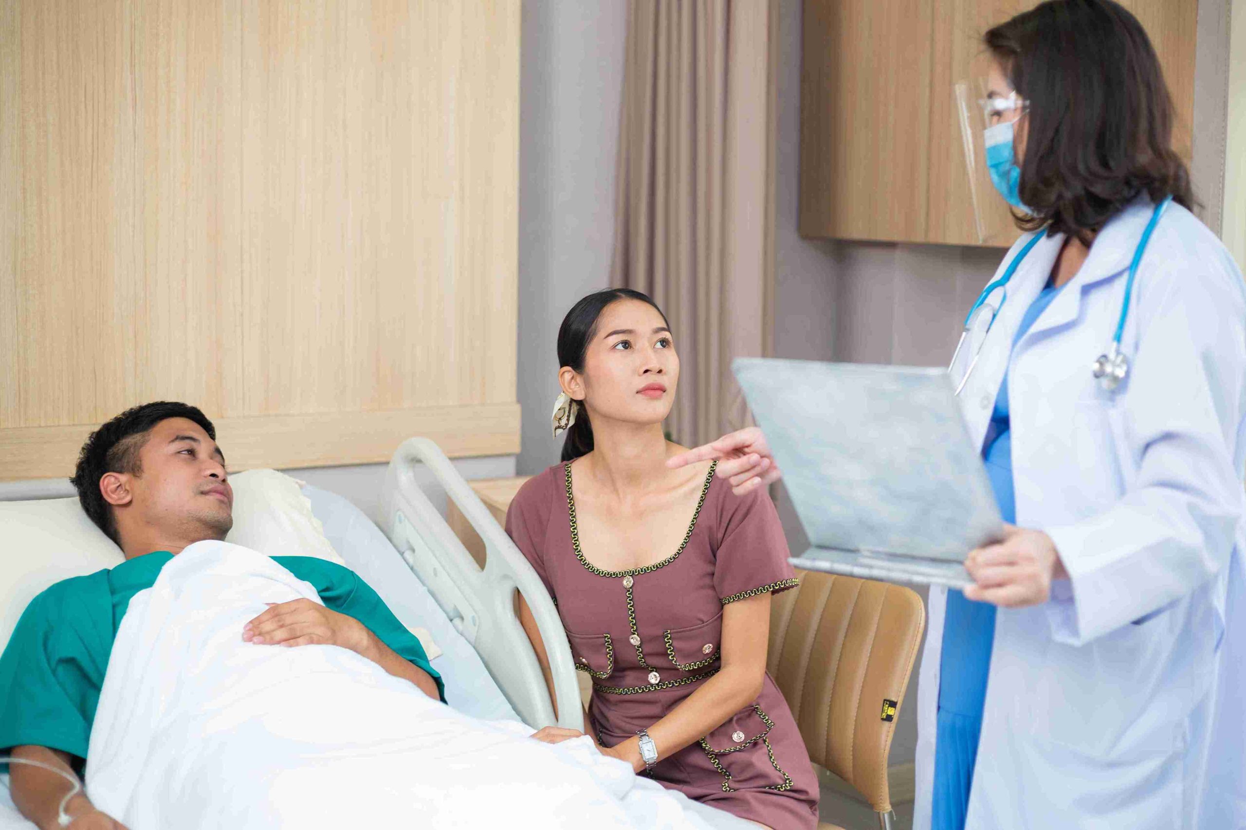 doctor speaking with a patient lying in a hospital bed