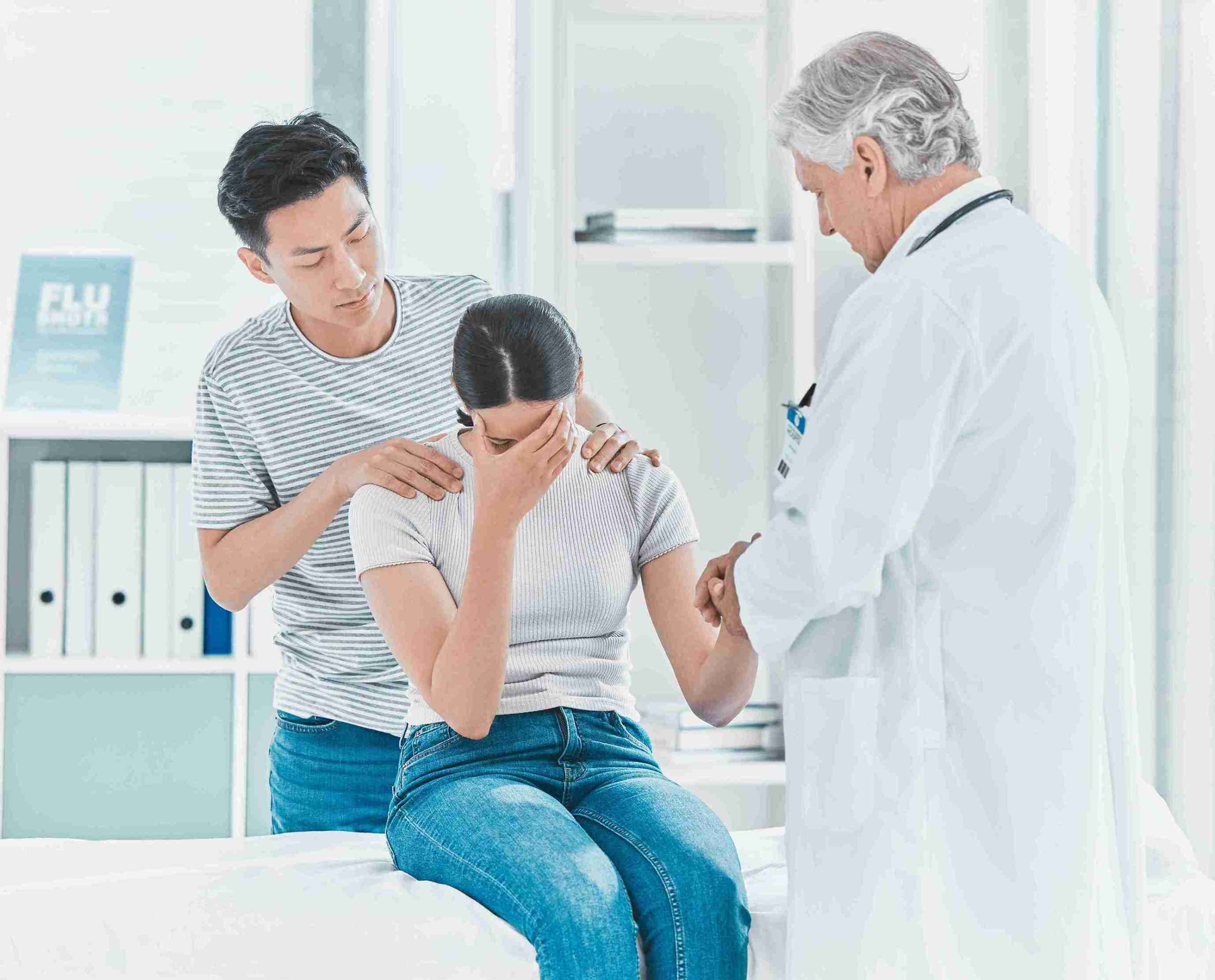 female patient crying and comforted by a doctor