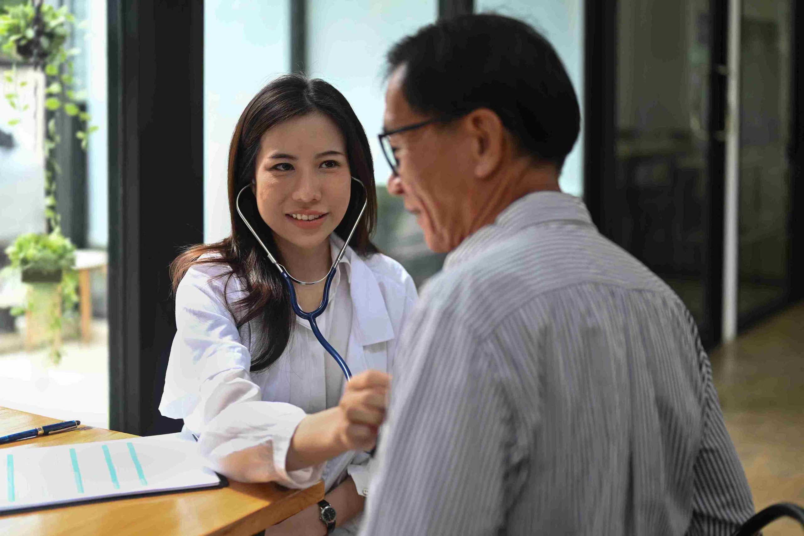 young female doctor examining an elderly patient