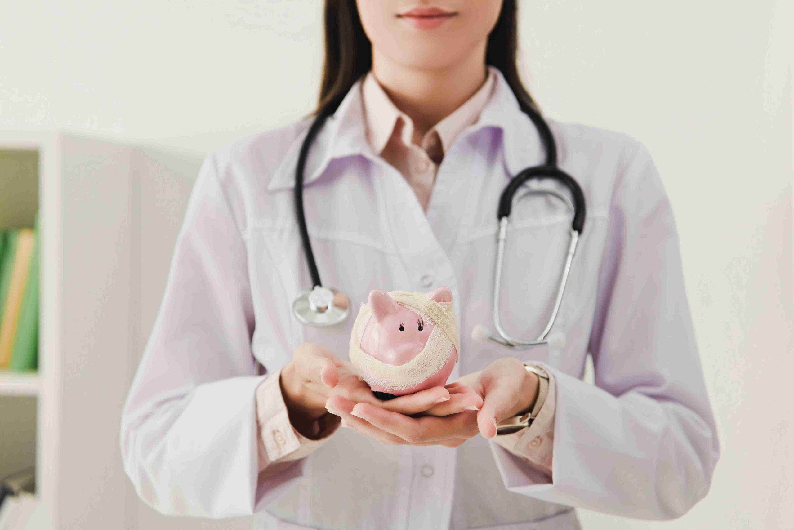 healthcare worker holding a bandaged piggy bank