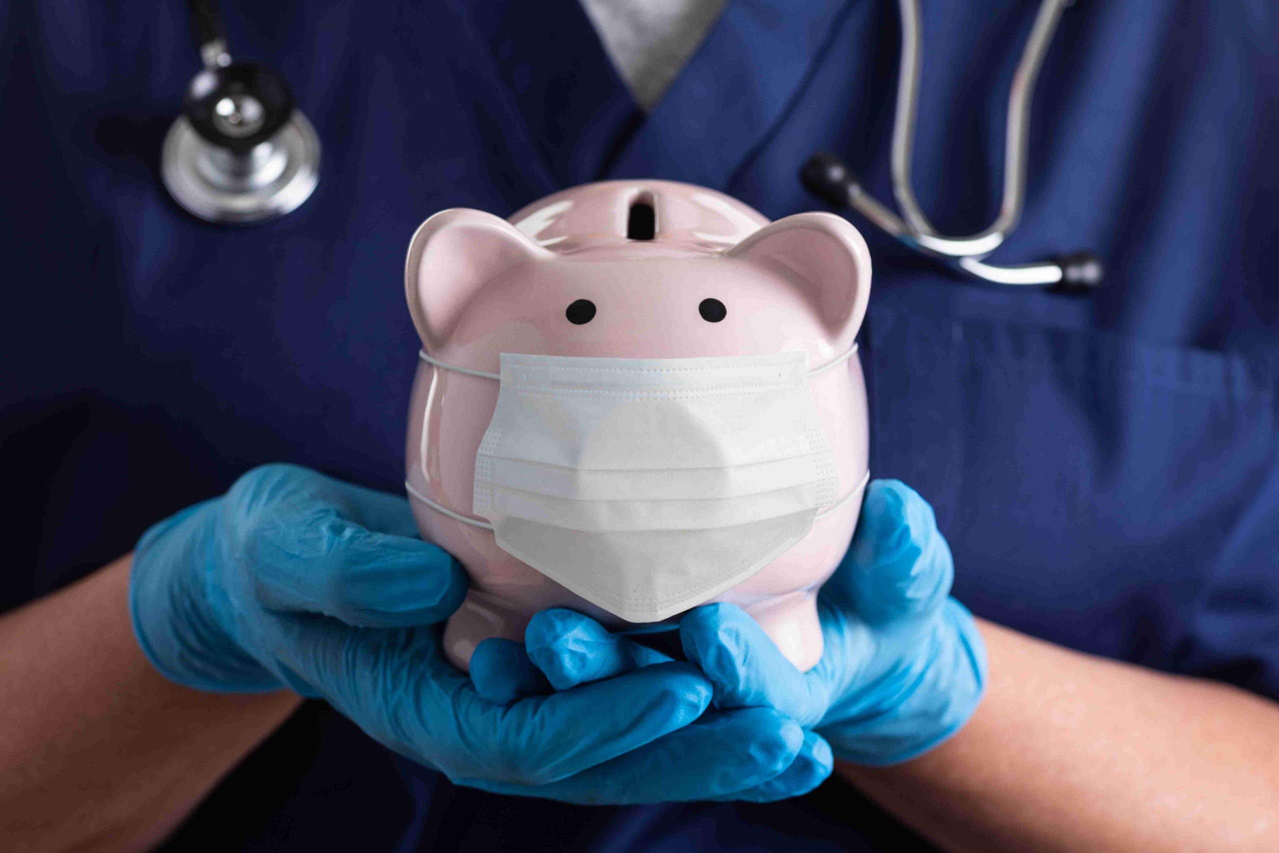 healthcare worker holding a piggy bank