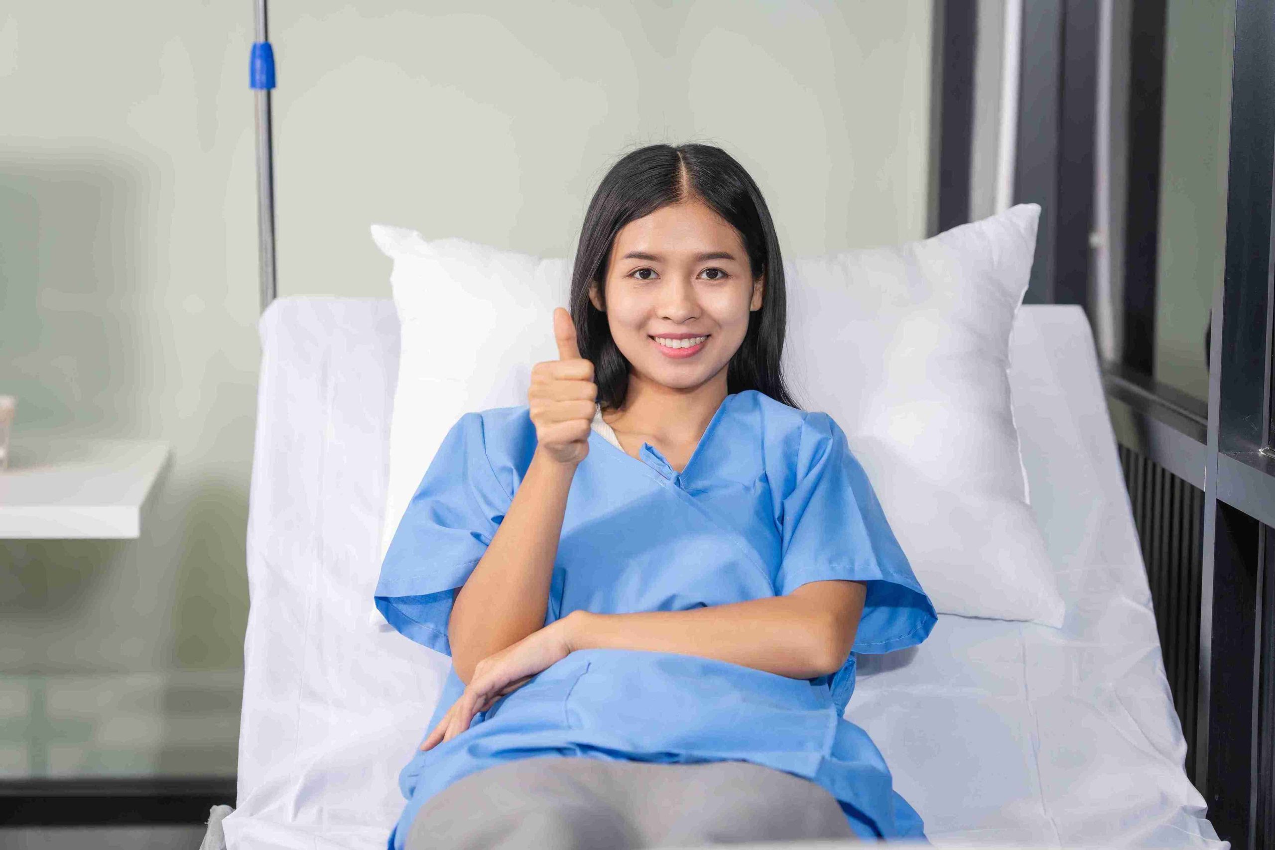 patient in the hospital bed giving a thumbs up