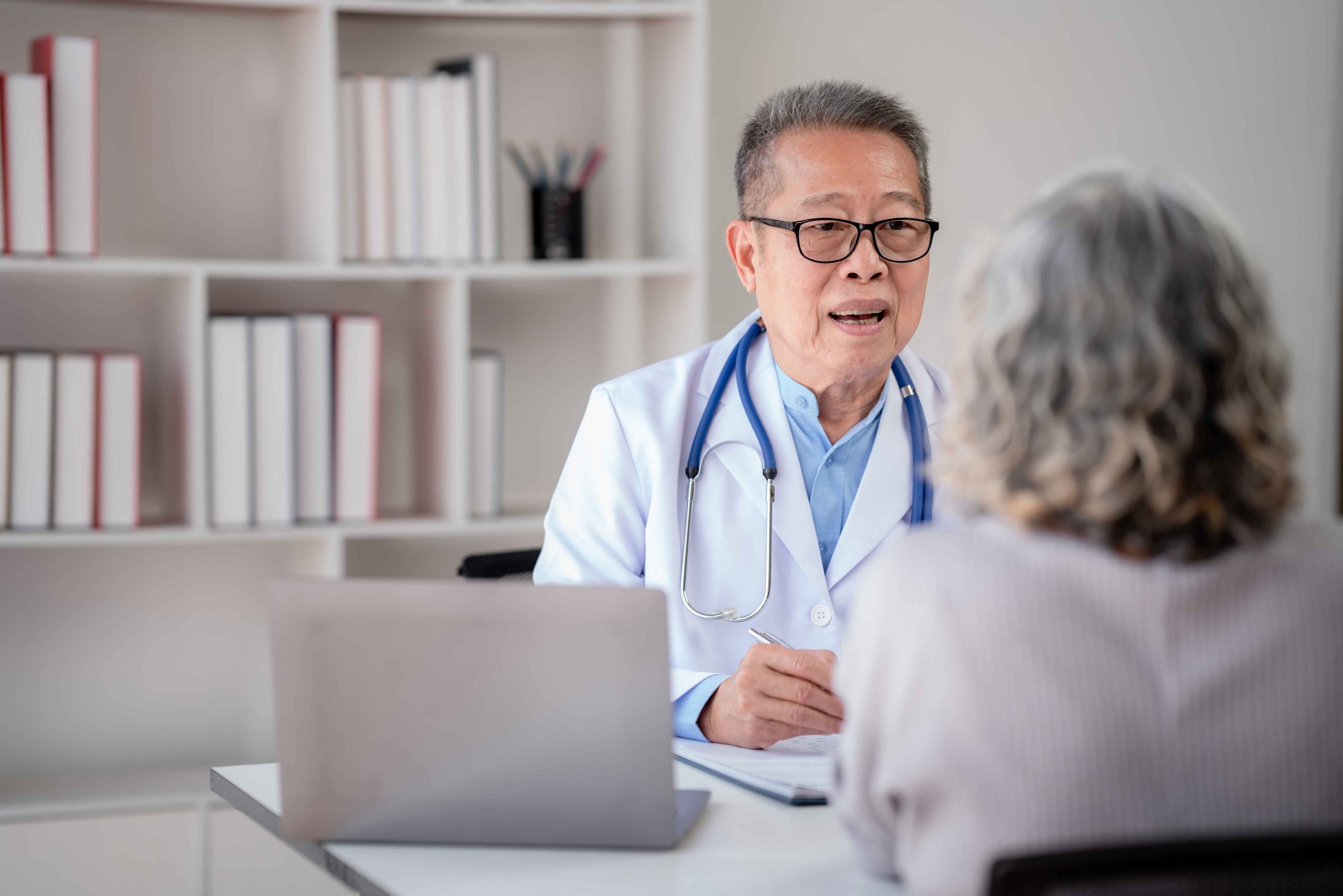 elderly doctor speaking with an elderly patient