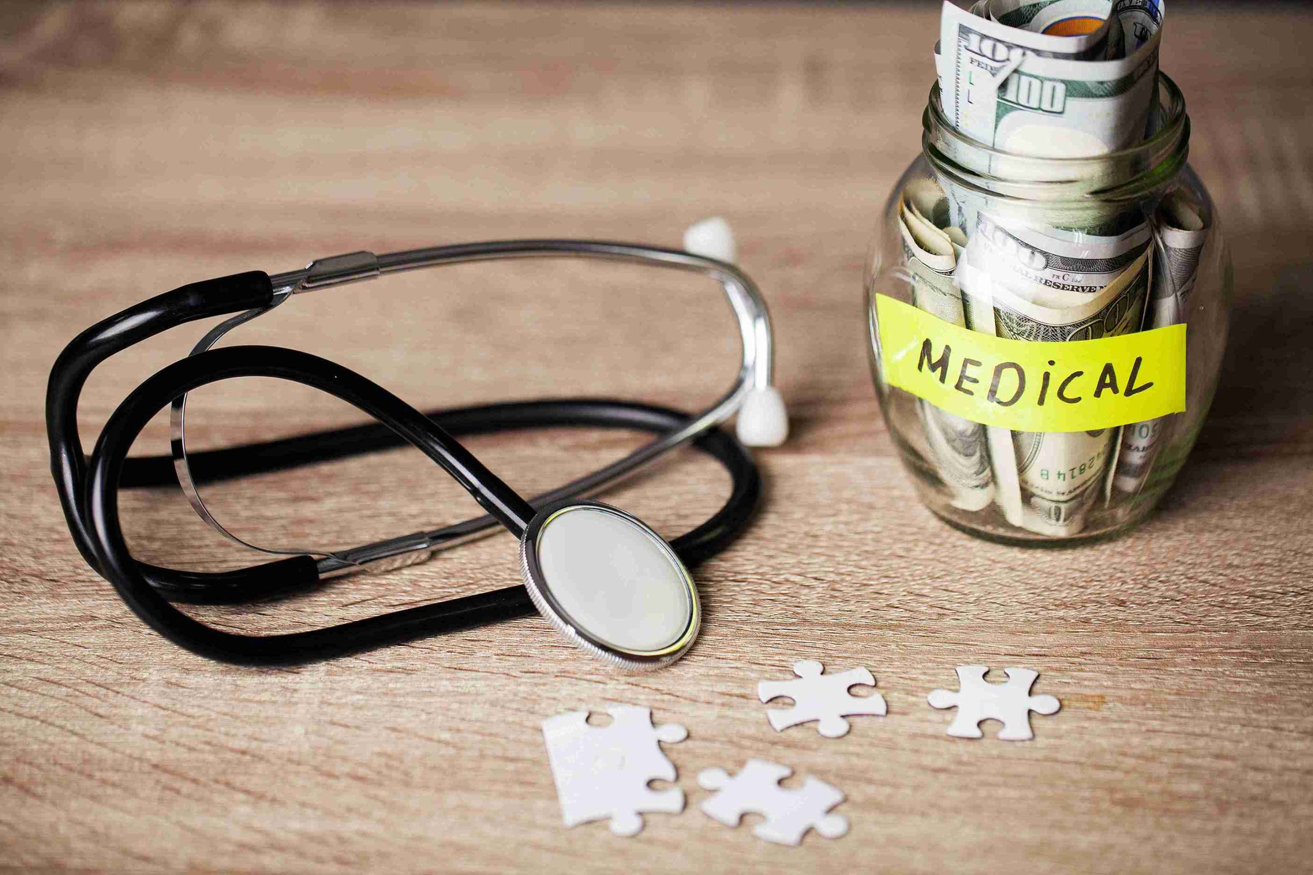 money in a glass jar with stethoscope