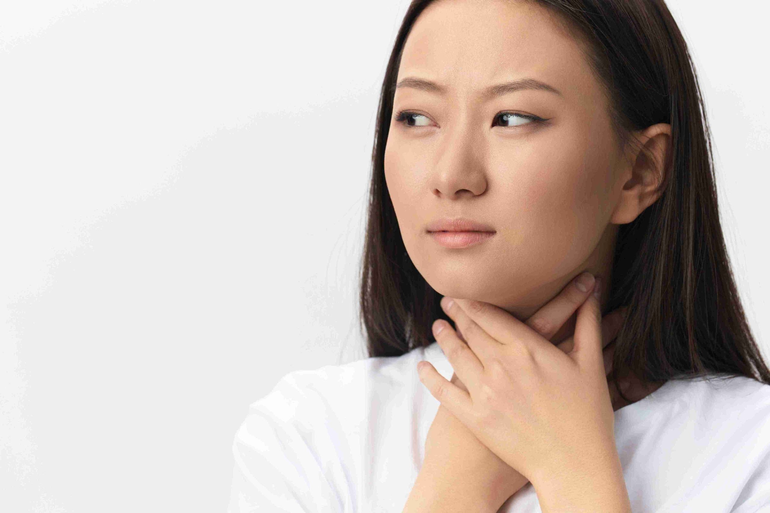 girl holding her neck due to swallowing difficulties
