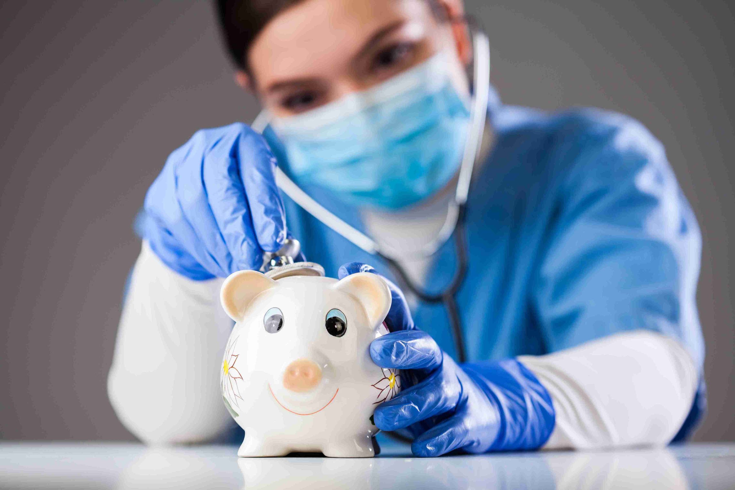 doctor inspecting a piggy bank using a stethoscope