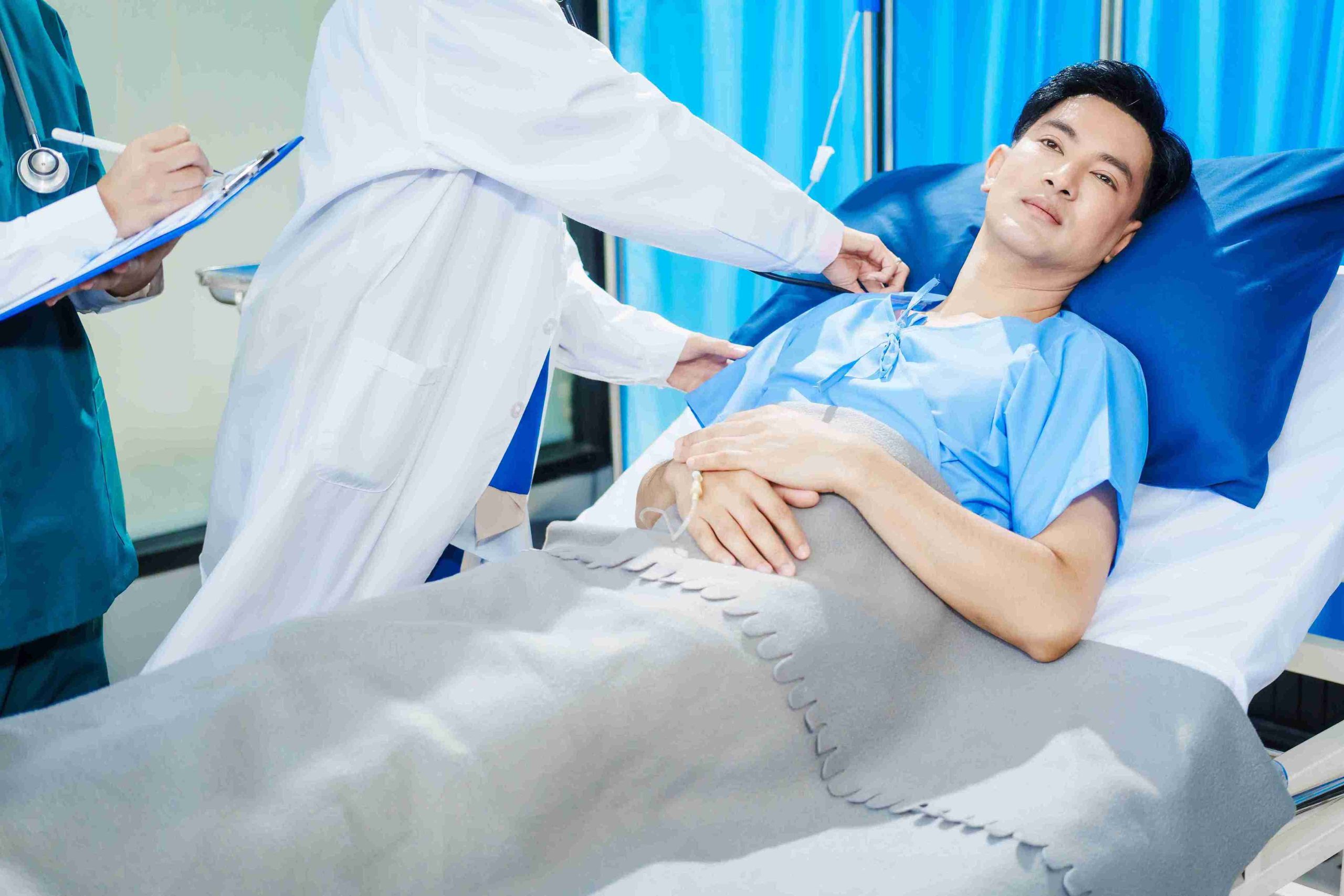 doctor checking on a male patient lying in the hospital