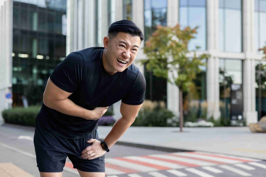 man with stomach pain while jogging