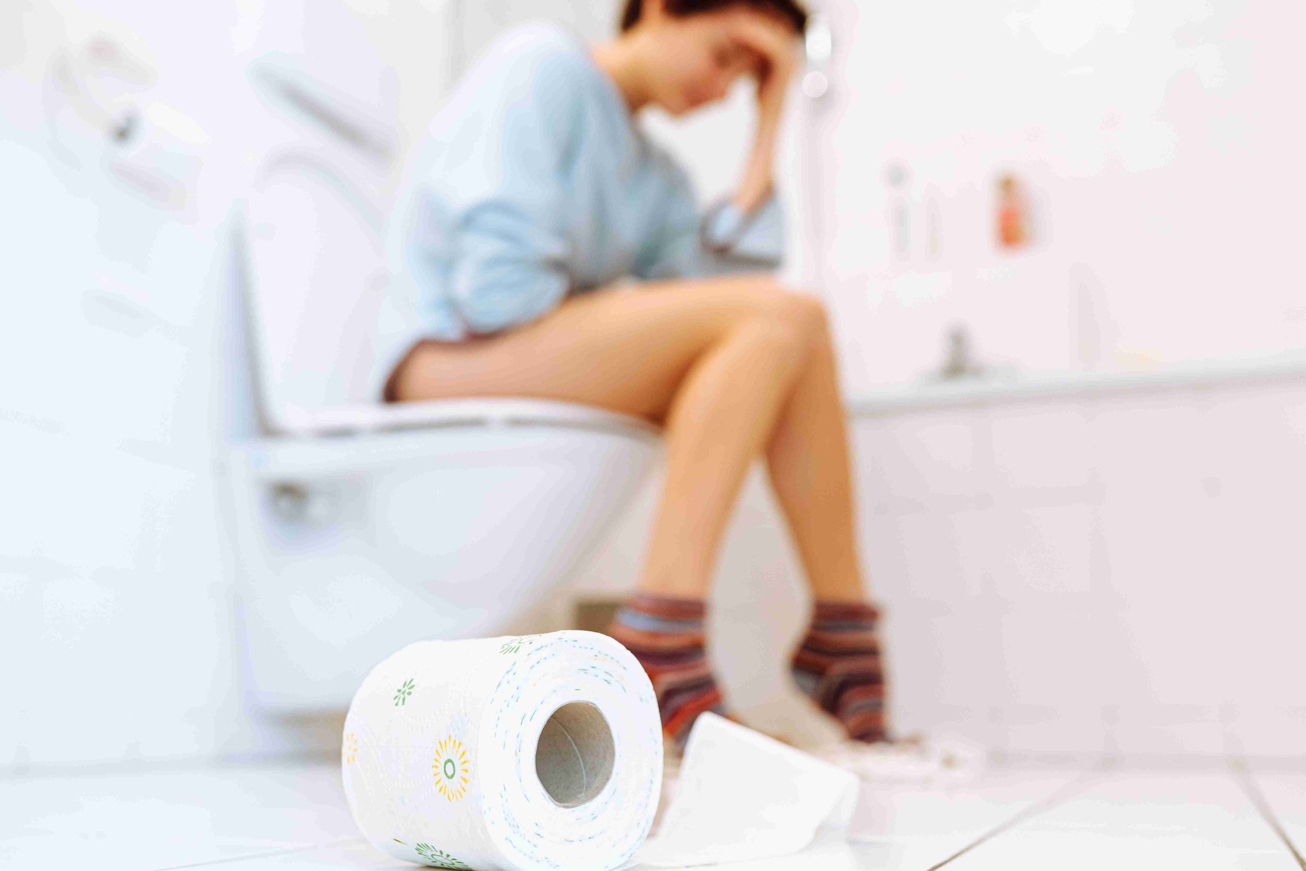 worried woman sitting in the toilet bowl