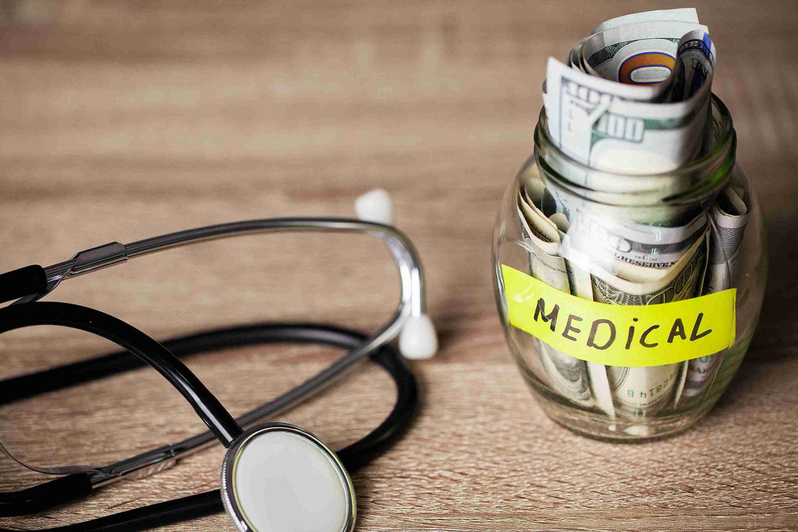 stethoscope and glass jar with money inside