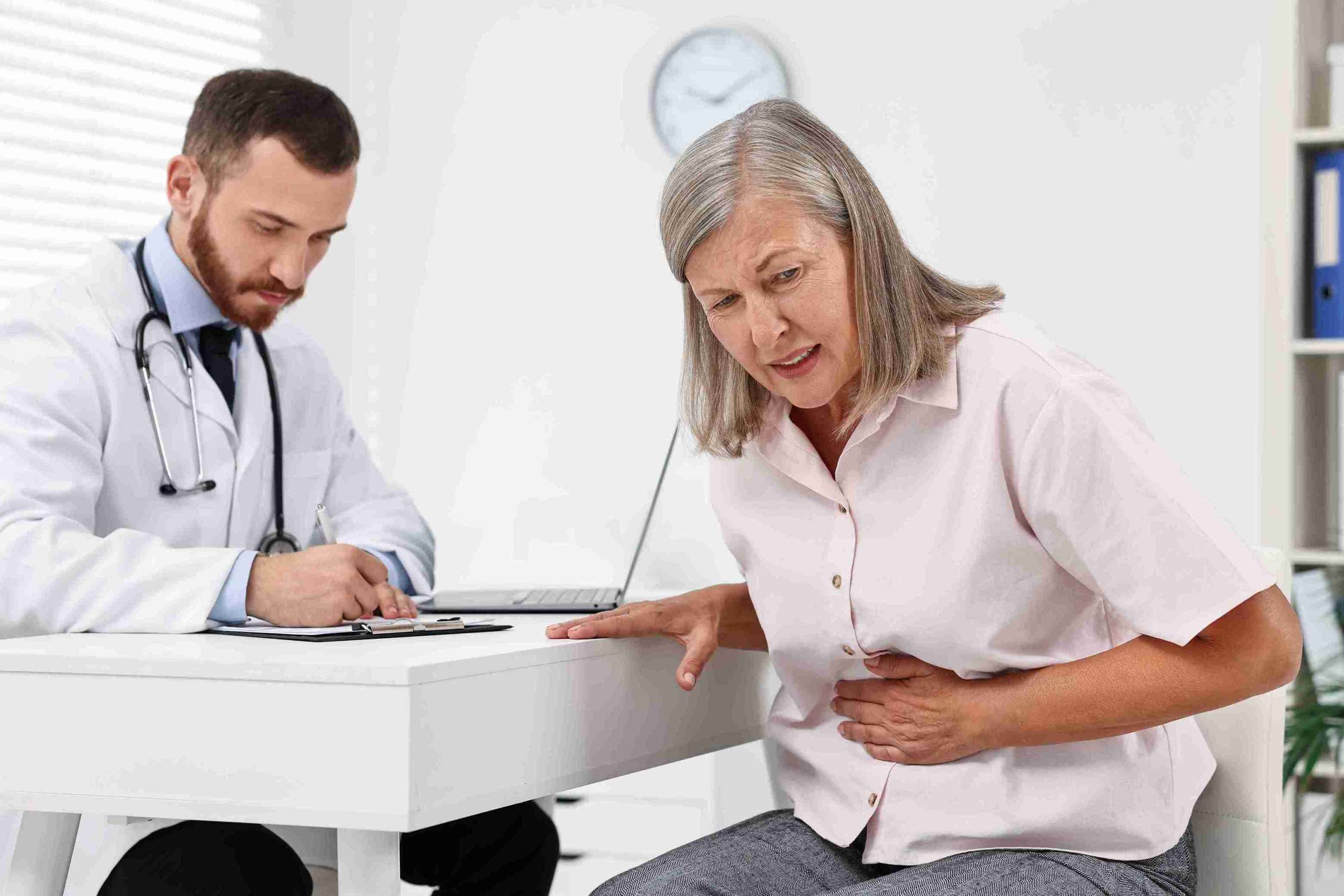 Elderly patient with stomach pain visiting a doctor.