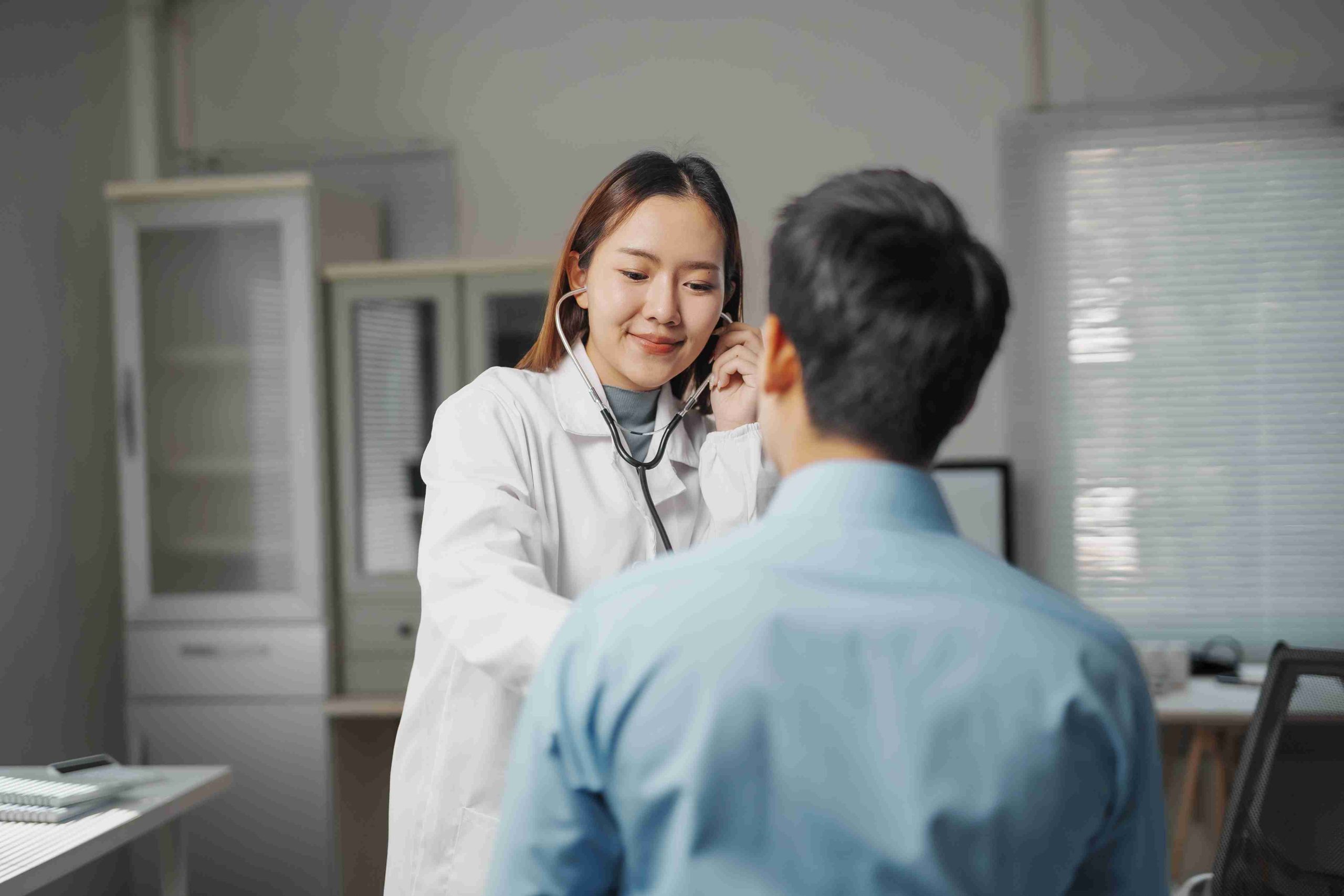 Young female doctor examining a male patient.
