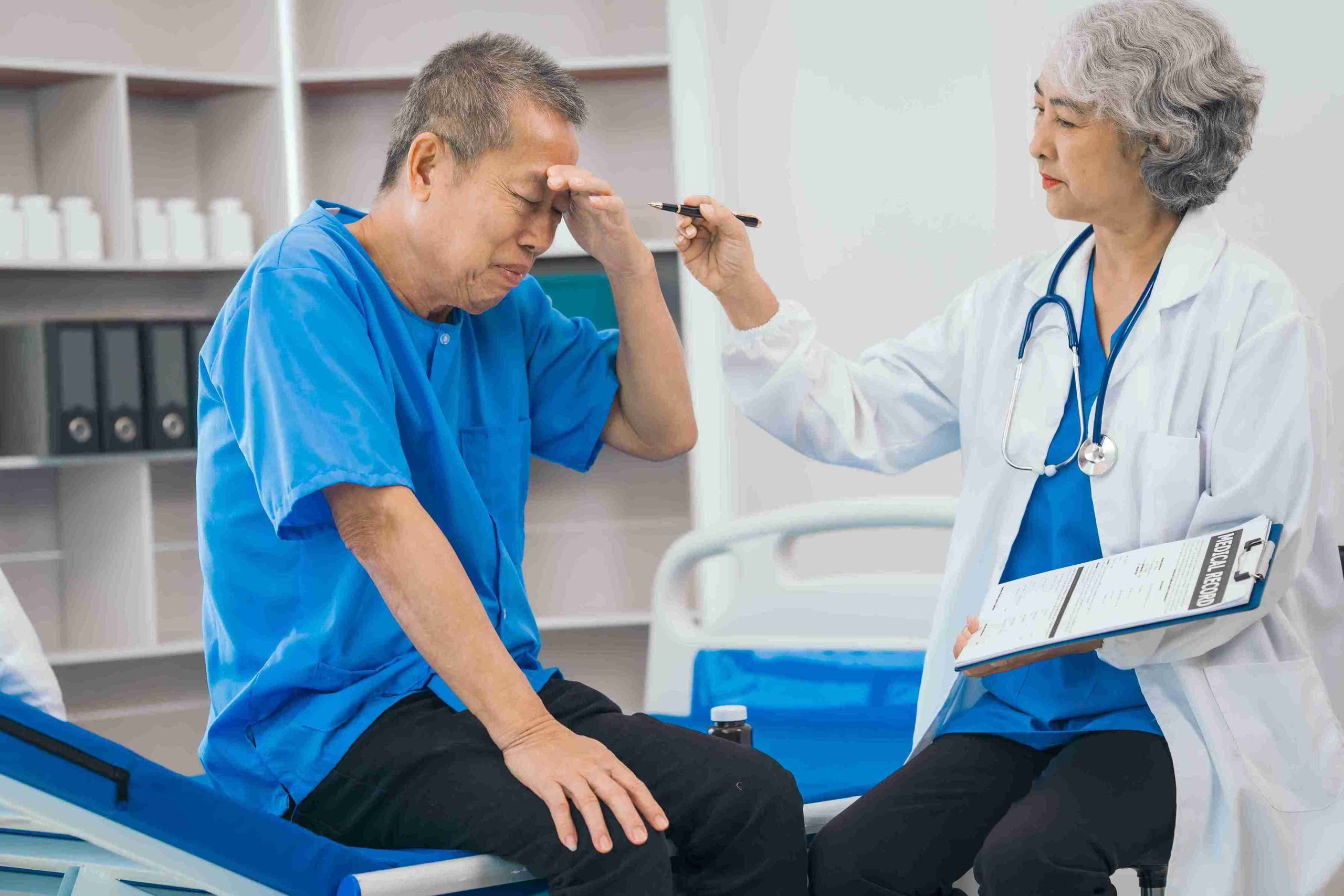 Male elderly patient looking confused while examined by a doctor.