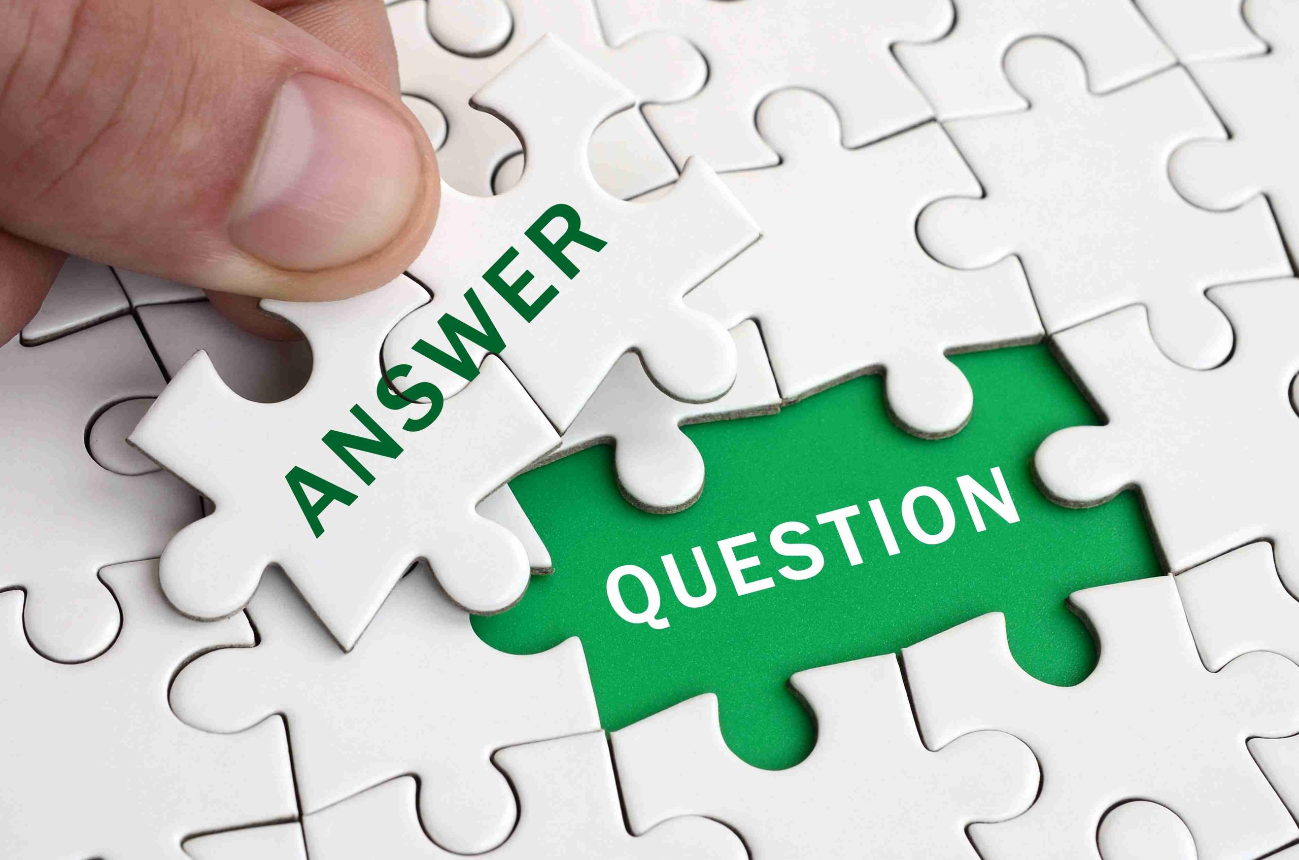 Hand holding the answer piece in a puzzle.