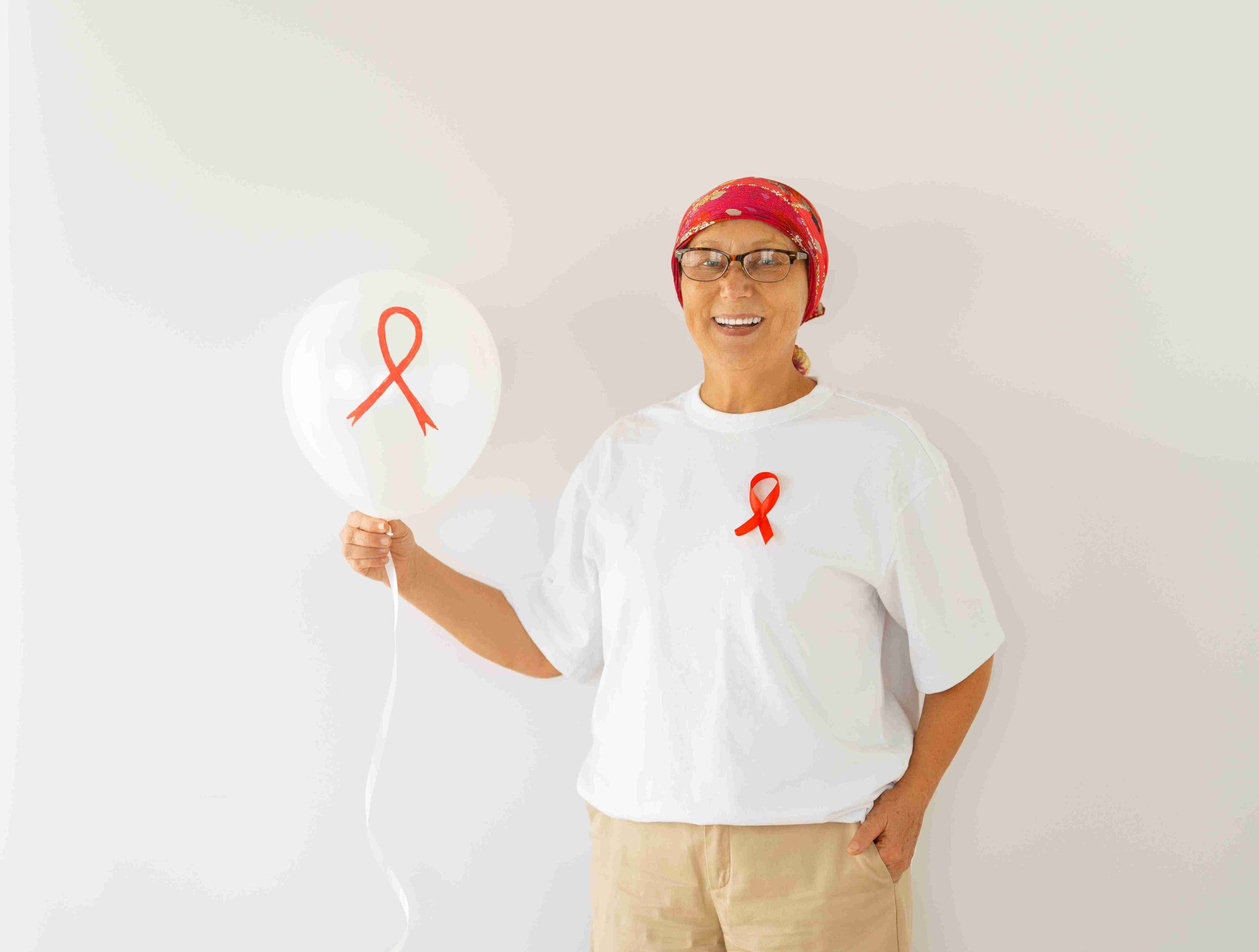 Woman smiling while holding a red satin ribbon.