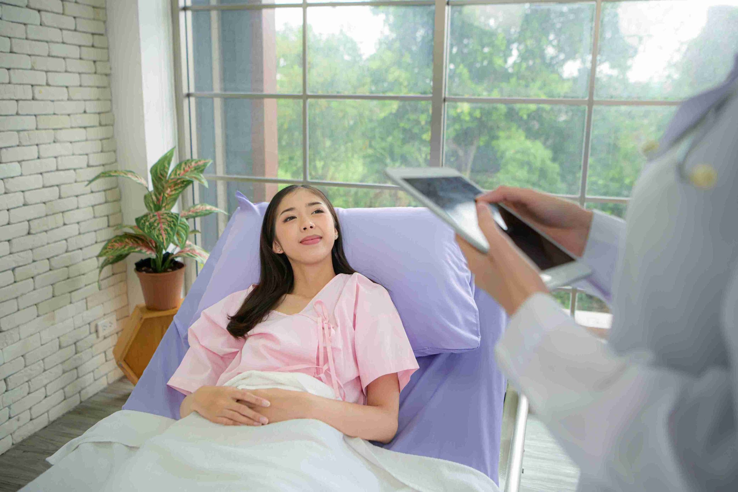 Doctor speaking with a patient lying in the hospital bed.