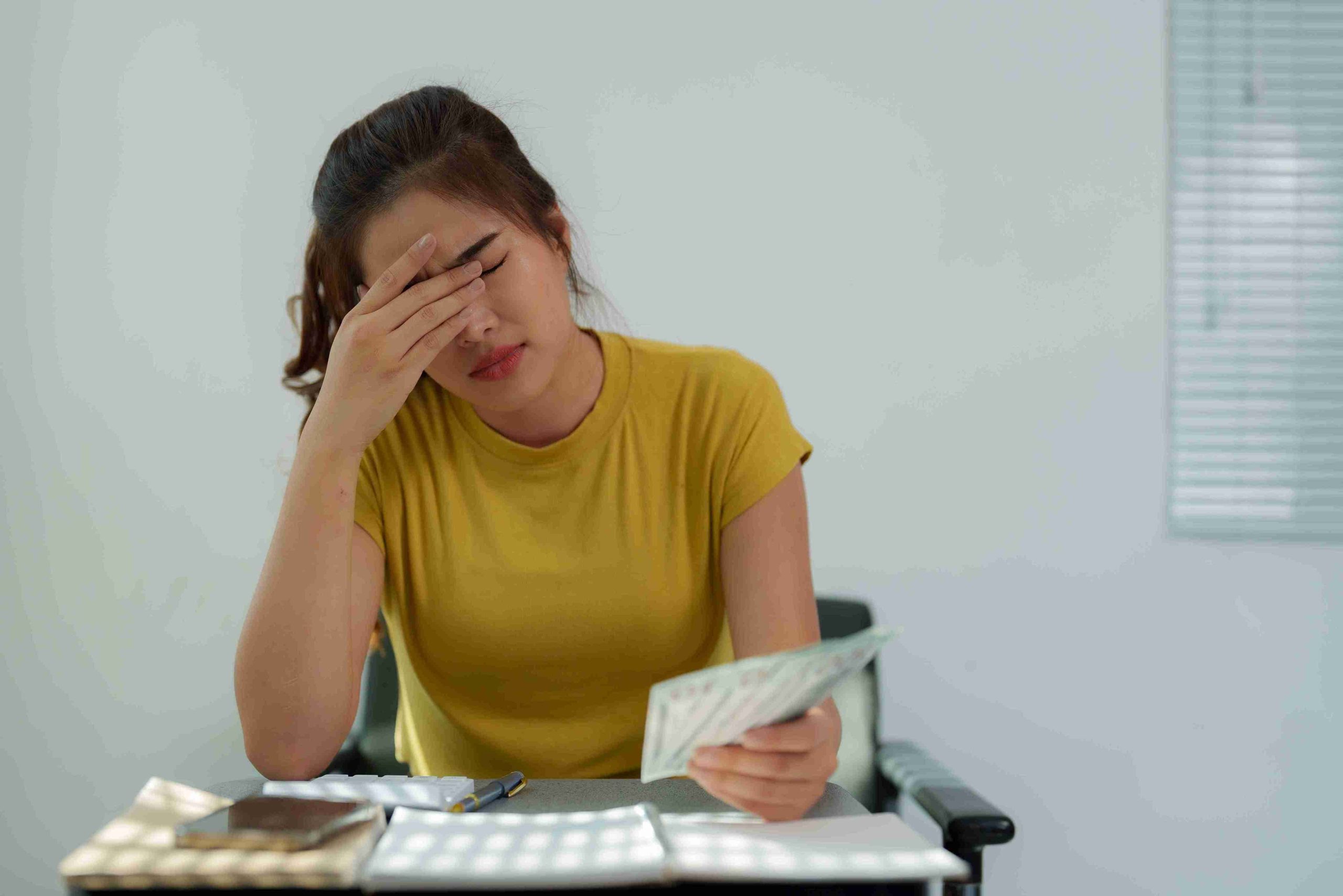Female patient holding money and looking stressed.