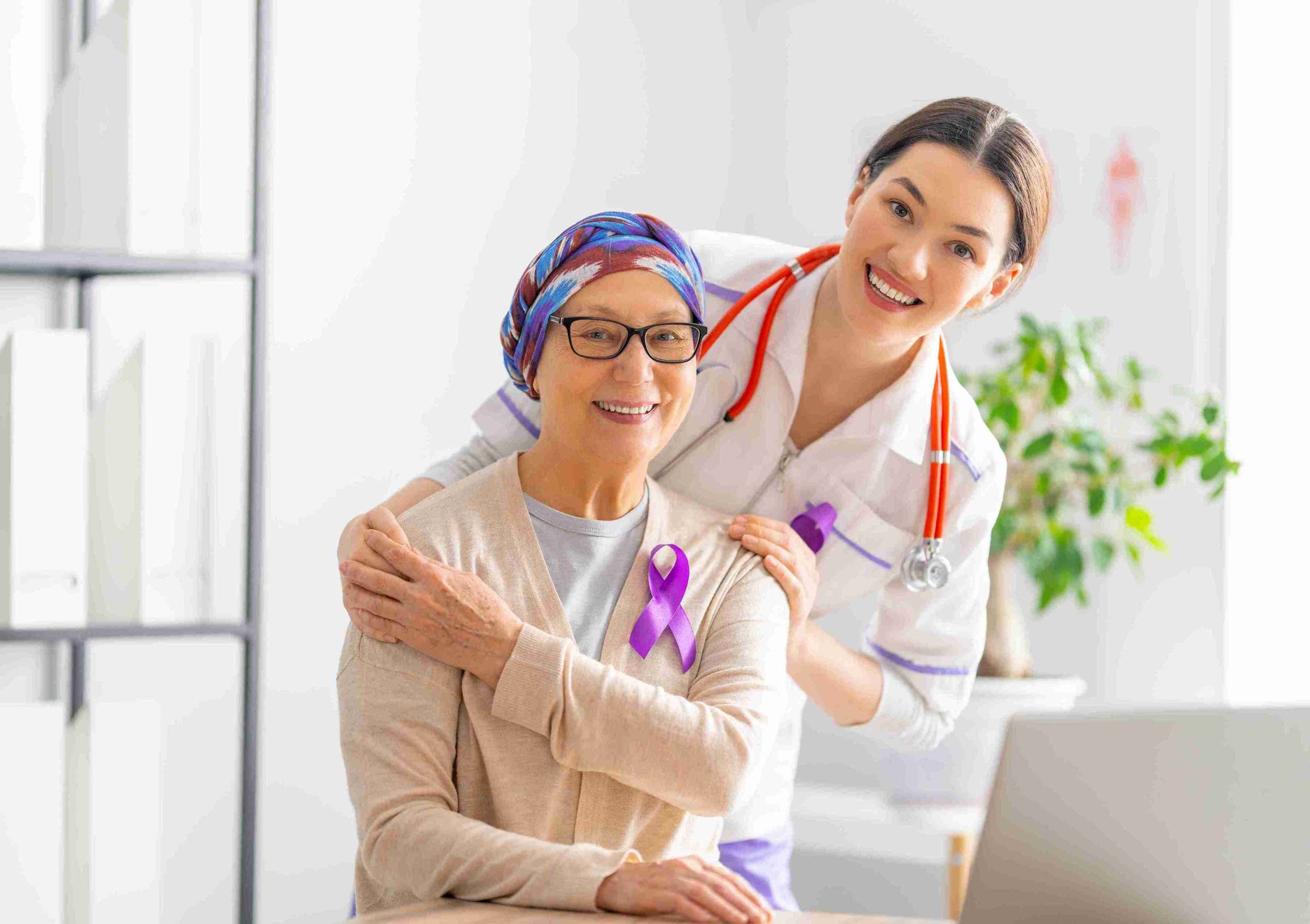 Cancer patient with her doctor posing for the camera and smiling.