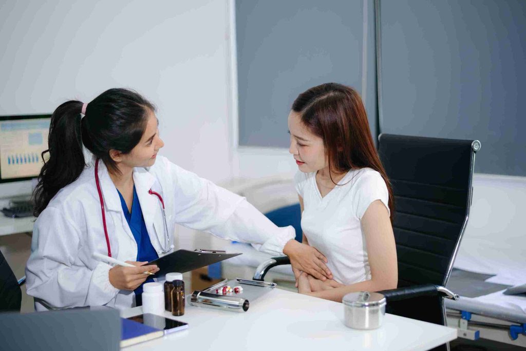 Female doctor examining the stomach of a patient.