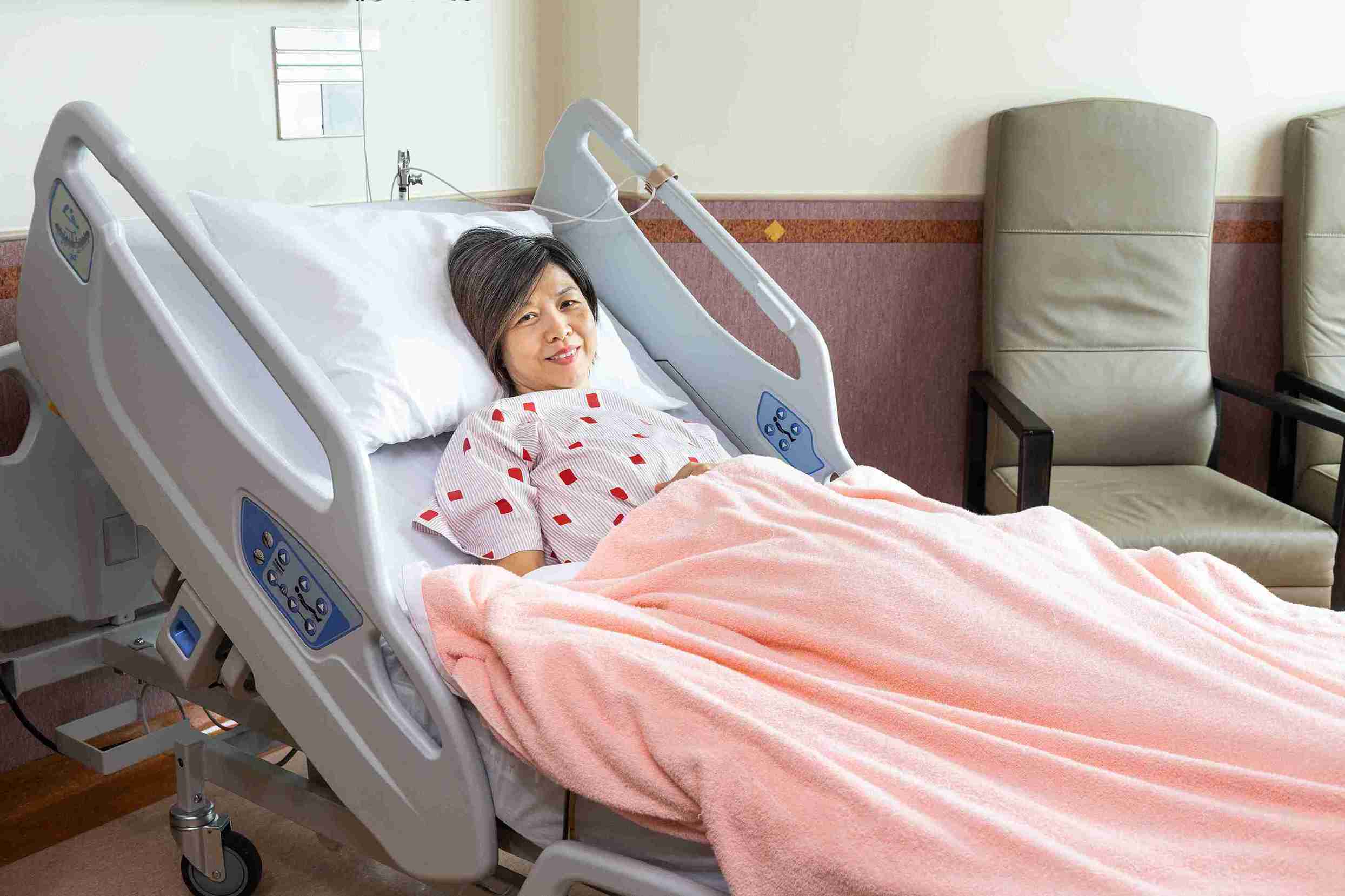 Woman lying in the hospital bed smiling.