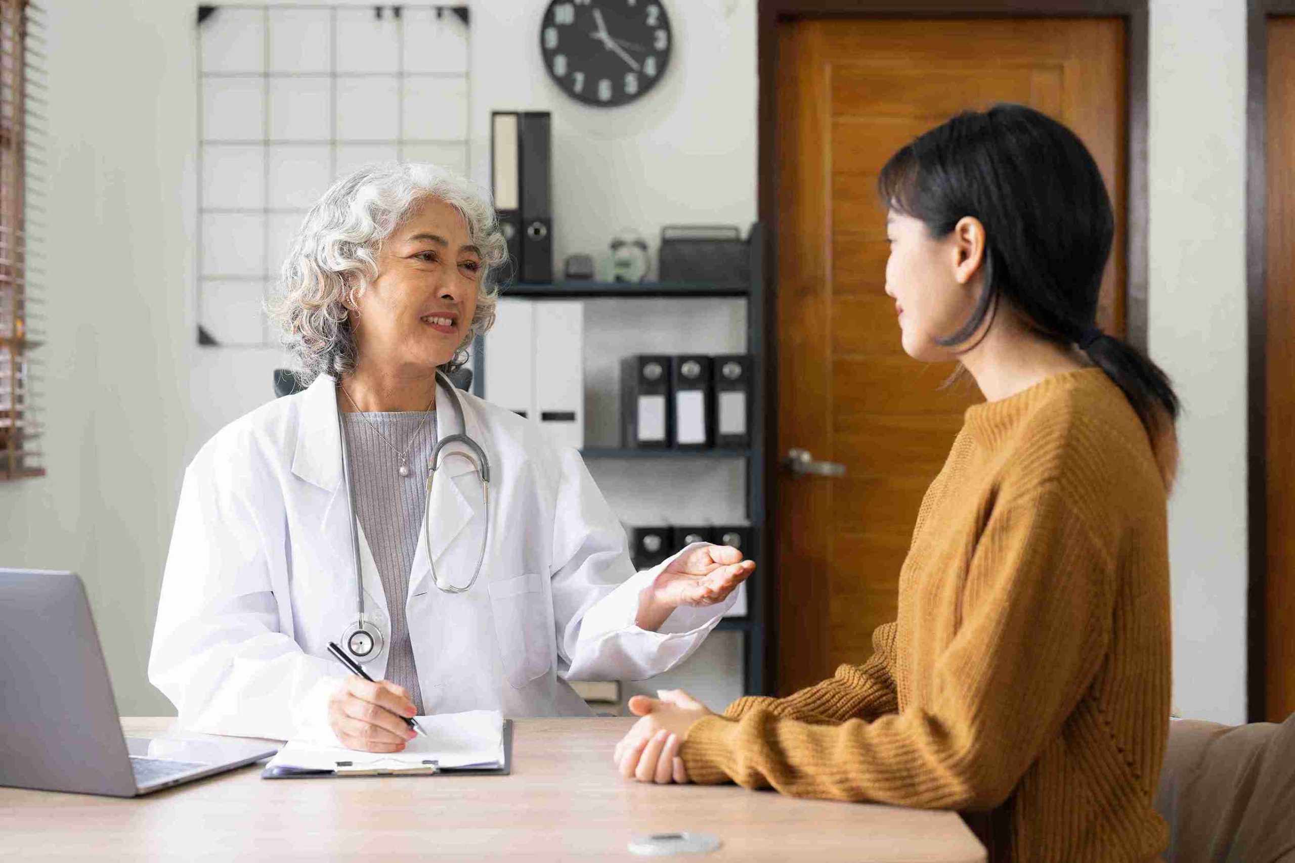 Elderly female doctor speaking with her patient.