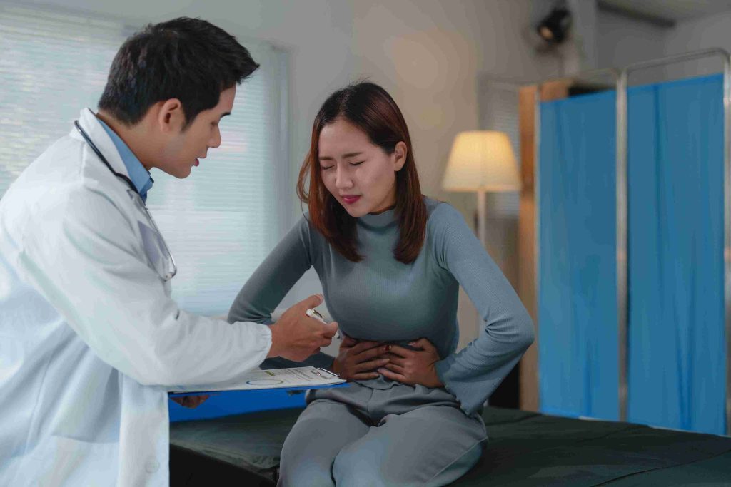 Woman with stomachache examined by doctor.
