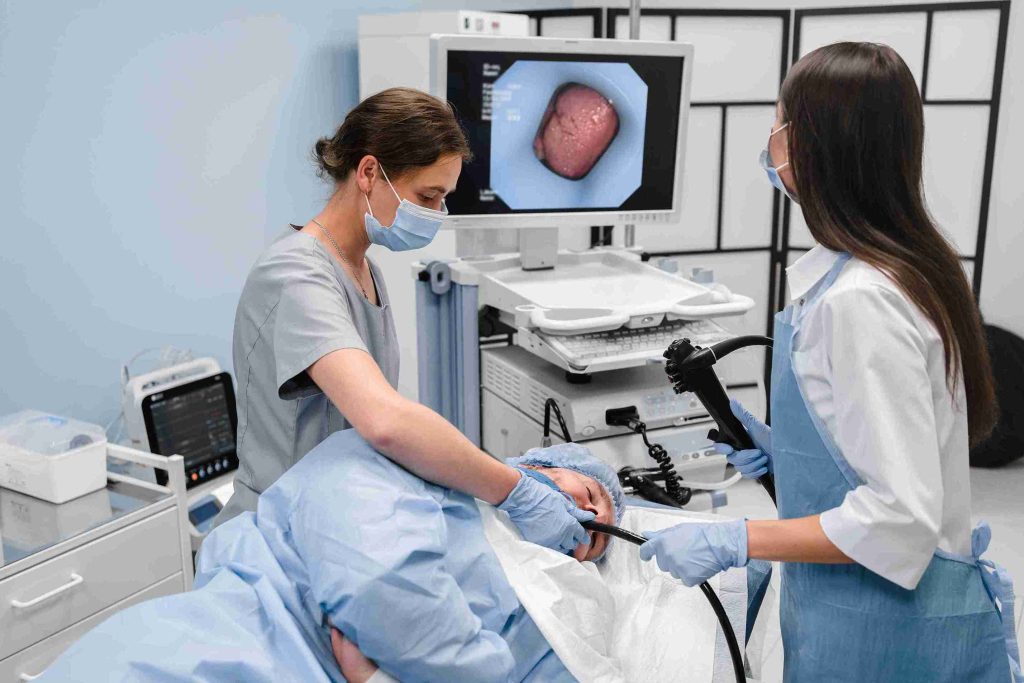 Doctors performing gastroscopy on a patient.