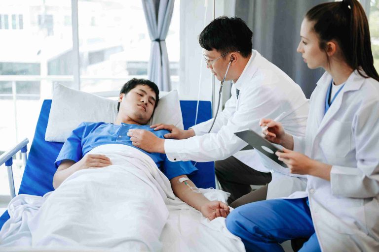 Two doctors checking on a patient lying in a hospital bed.