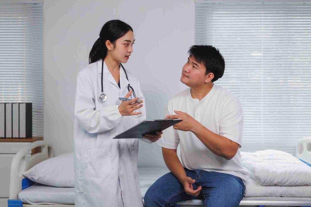 Patient sitting in the hospital bed consulting with his doctor.