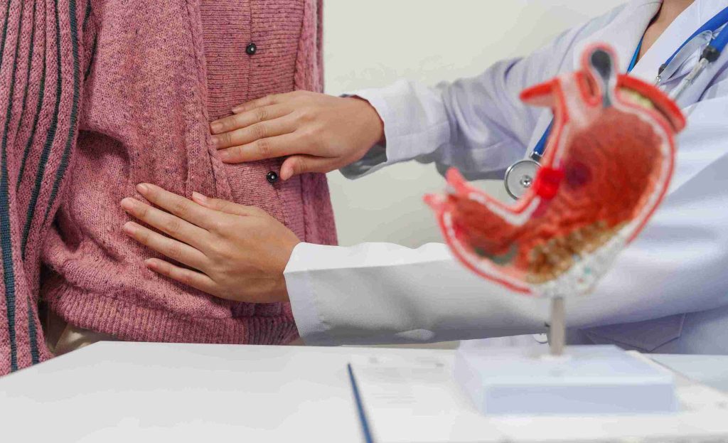 Doctor examining a patient with gastric pain.