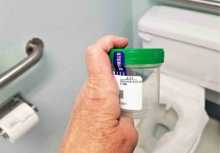 Patient preparing stool specimen for examination.