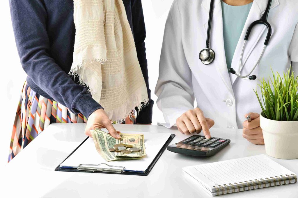 Patient paying the doctor money for a medical procedure.