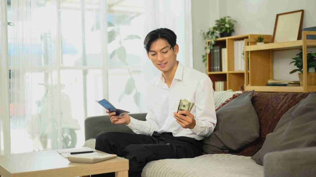 Young man counting money he saved from medical procedures.