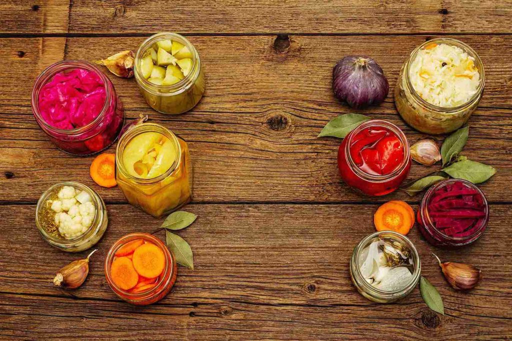 An image of assorted fermented vegetable placed in glass jars.