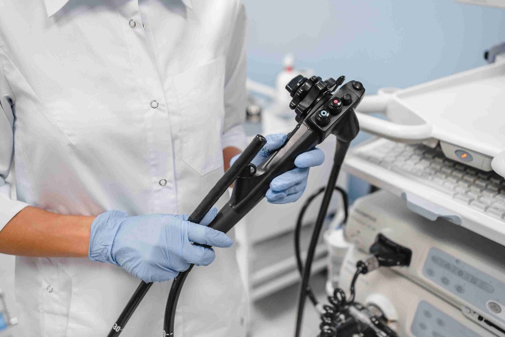 Healthcare worker holding an instrument used for endoscopy.
